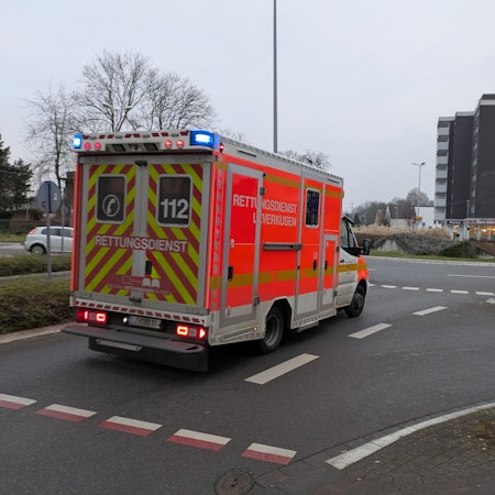 Ein Rettungswagen fährt mit Blaulicht auf den Berliner Platz in Opladen.