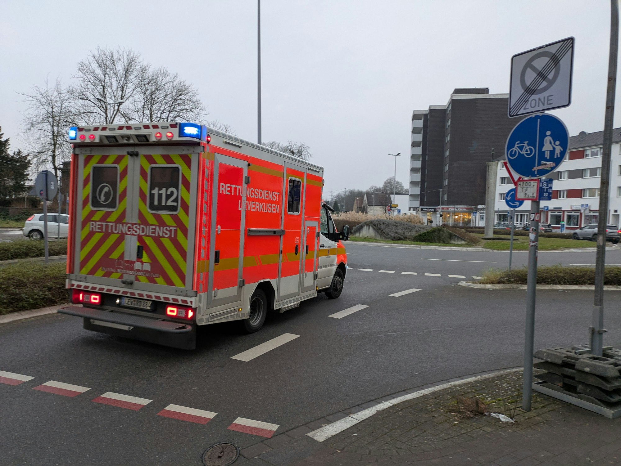 Ein Rettungswagen fährt mit Blaulicht auf den Berliner Platz in Opladen.