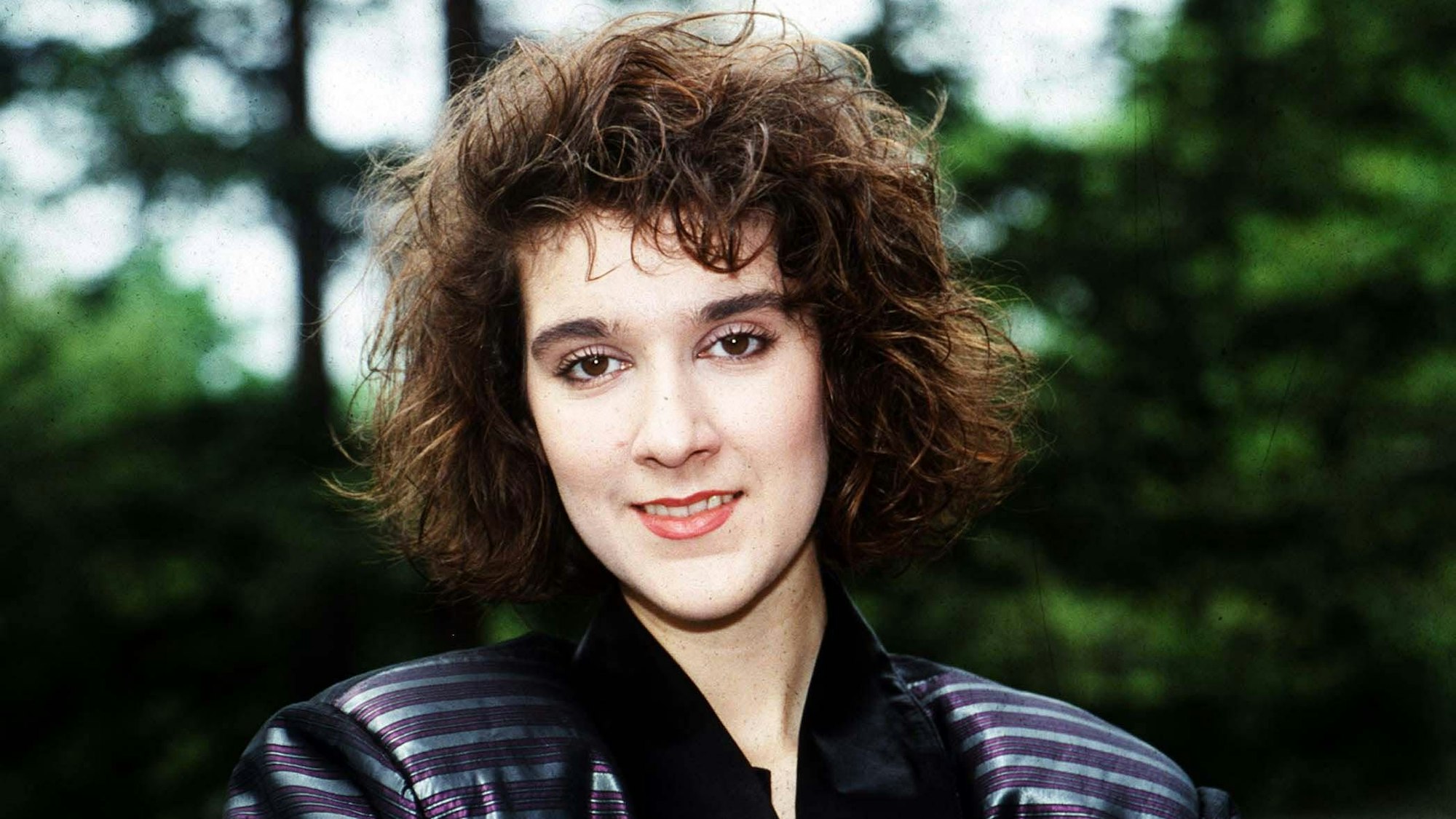 Céline Dion mit wilder Lockenfrisur.