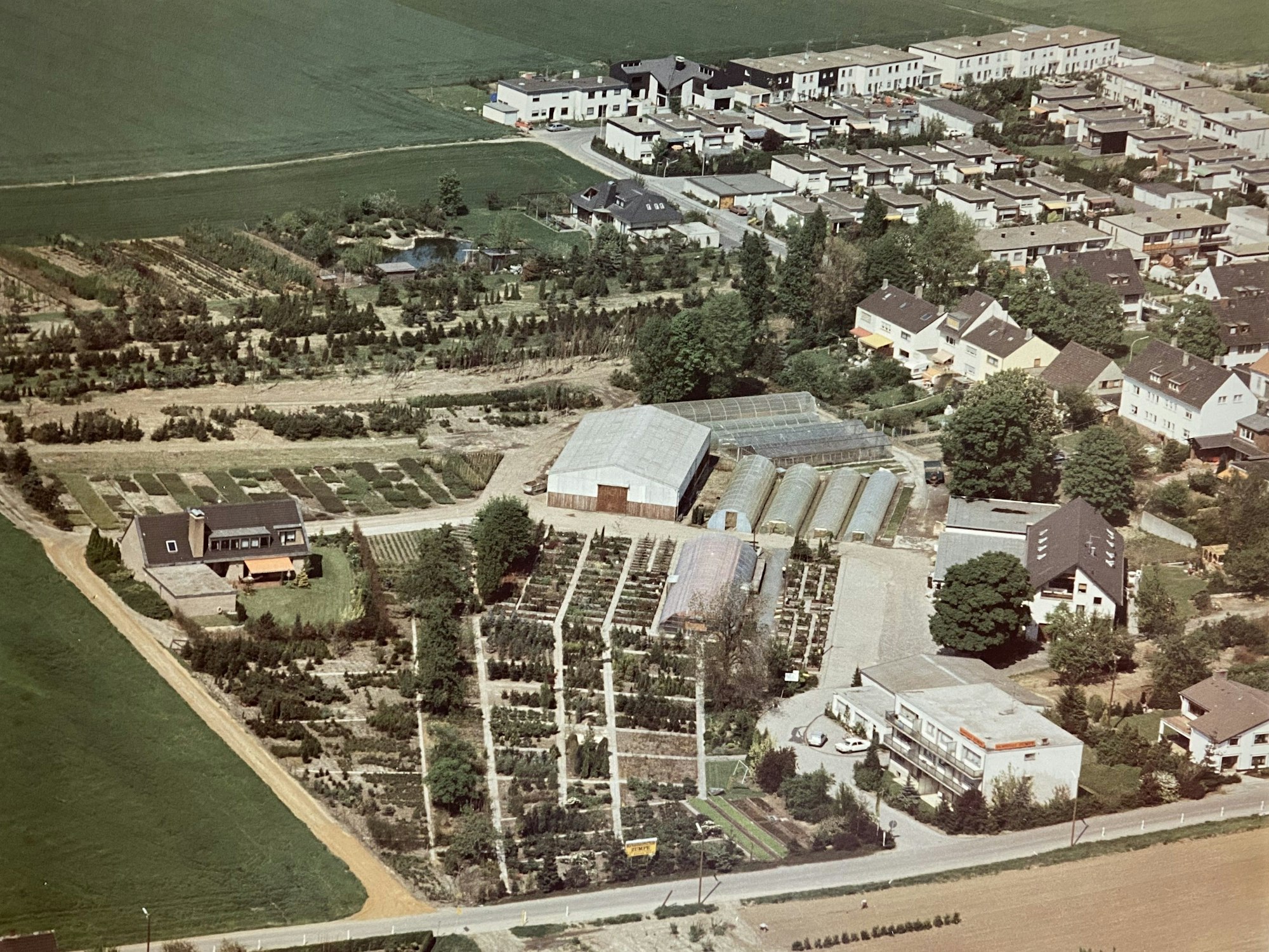 Das Bild zeigt eine Luftaufnahme des alten Firmengeländes, die um 1980 entstanden ist.