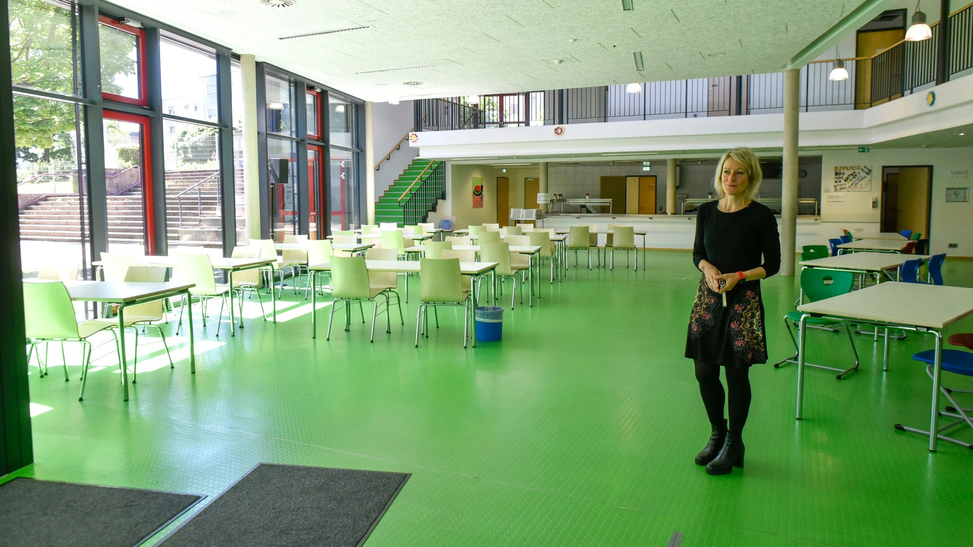 Auf dem Foto ist die Schulleiterin in der Mensa zu sehen.