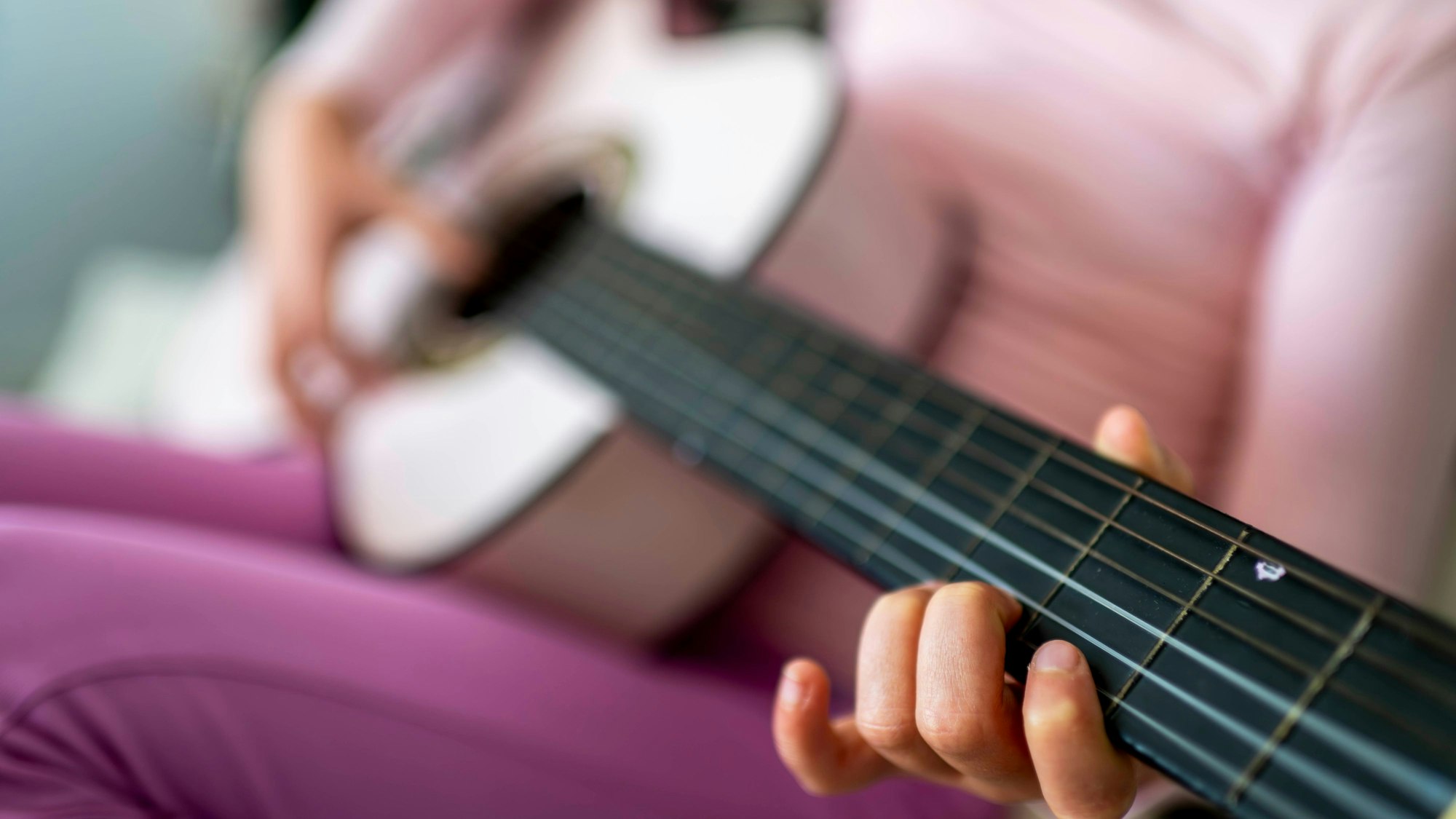 Das Symbolfoto zeigt ein Kind, das Gitarre spielt.
