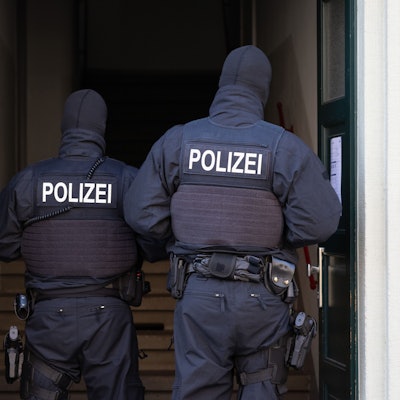 Polizisten stehen während einer Razzia gegen mutmaßliche Rechtsextreme in einem Hauseingang im Dresdner Stadtteil Cotta. (Archivbild)
