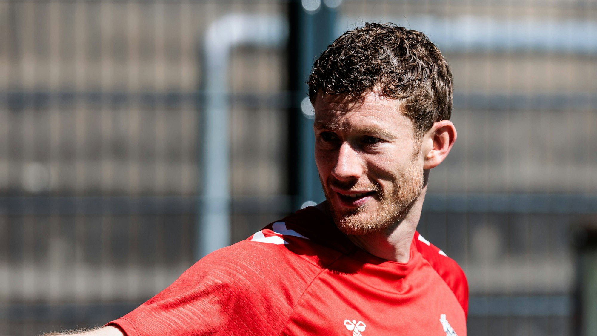 Ein Fußballspieler blickt hinter sich und lächelt.