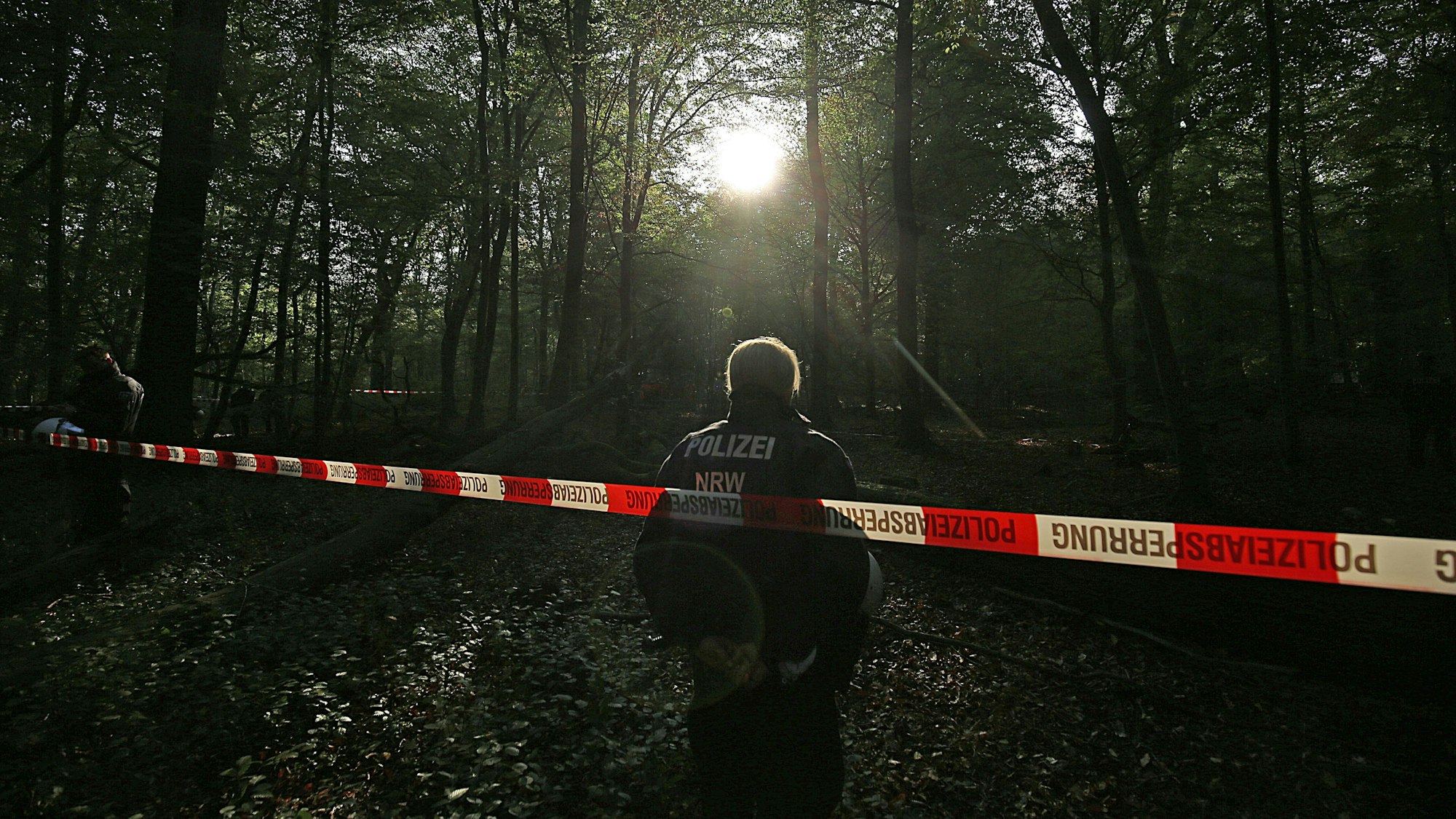 Die Polizei an einer Absperrung im Wald (Symbolfoto).