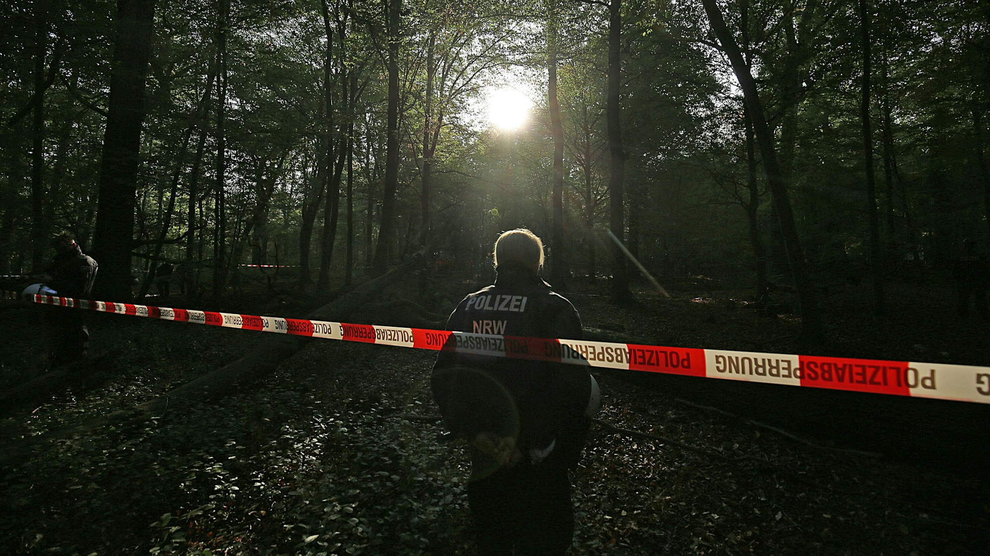 Die Polizei an einer Absperrung im Wald (Symbolfoto).