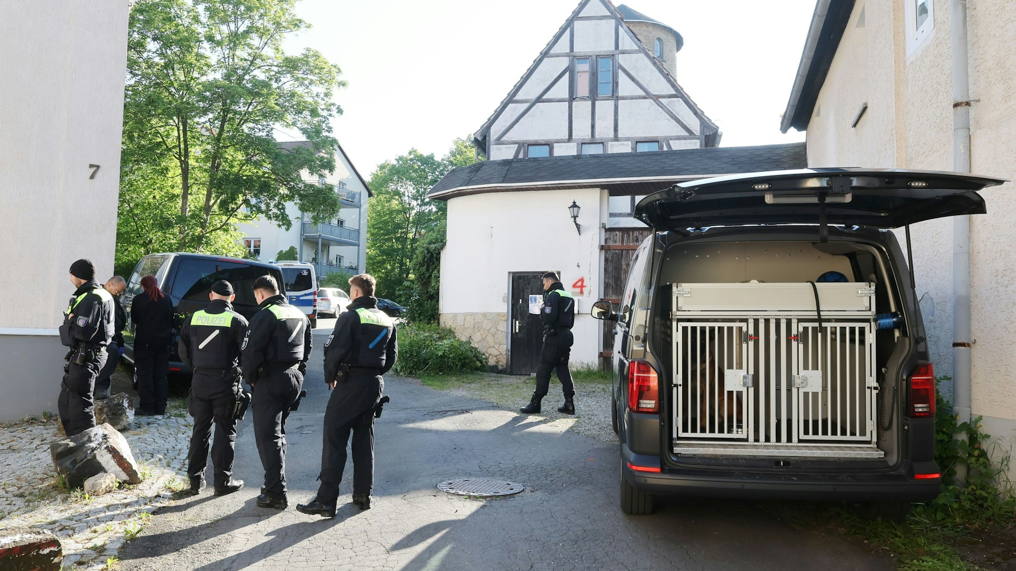 Mit Mitgliedern der Hundestaffel durchsuchen Polizeibeamte nach dem Verbot der Reichsbürger-Gruppe "Königreich Deutschland" durch den Bundesinnenminister ein Gebäude.