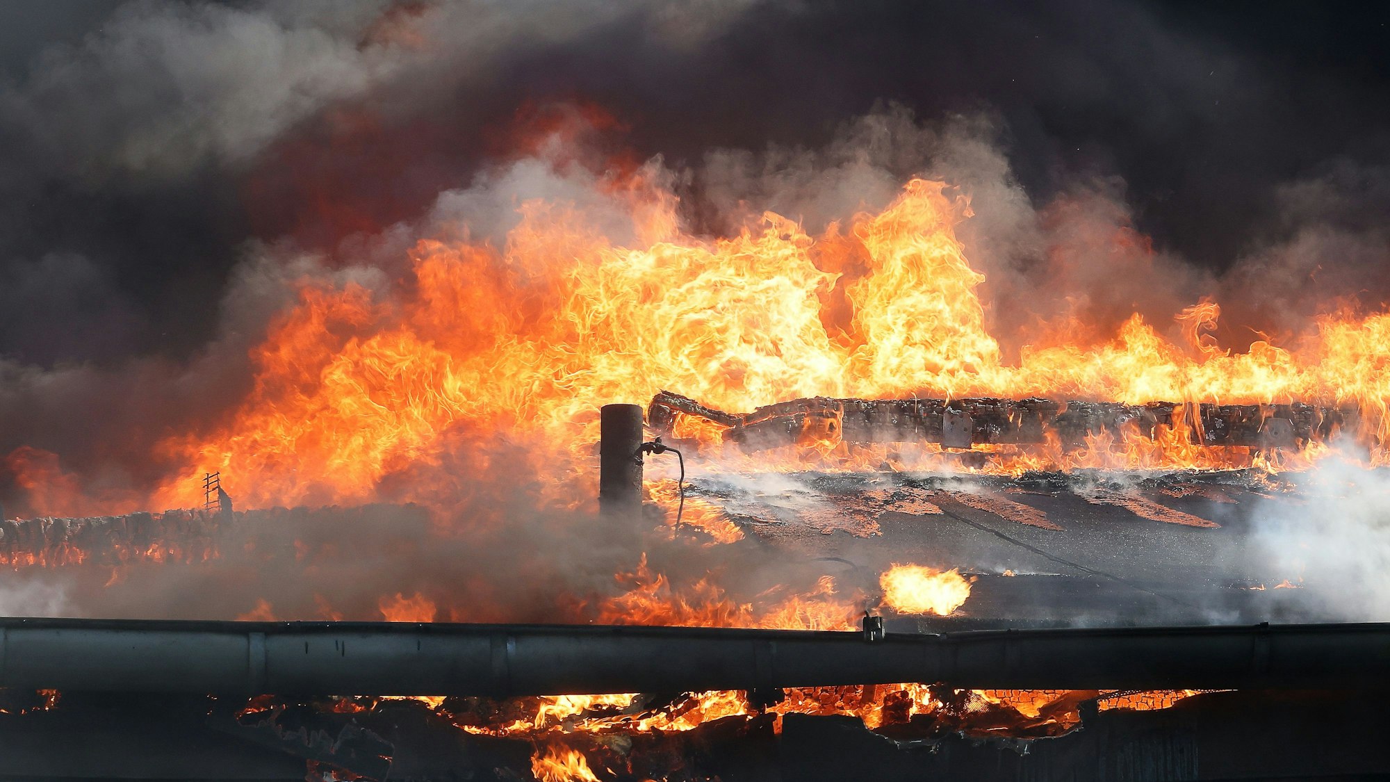 Flammen schlagen bei einem Großbrand aus dem Dach eines Gebäudekomplexes mit mehreren Schulen im Kreis Mettmann.