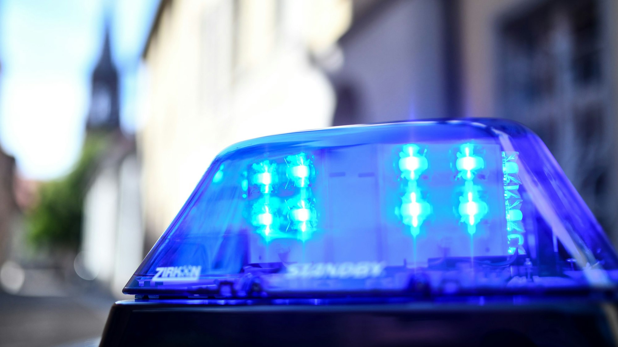 ARCHIV - 30.07.2018, Baden-Württemberg, Freiburg: Ein Polizeiauto mit blinkendem Blaulicht steht vor einem Gebäude. (zu dpa: «Schüsse im Kreis Ludwigsburg - Täter auf der Flucht») Foto: Patrick Seeger/dpa +++ dpa-Bildfunk +++