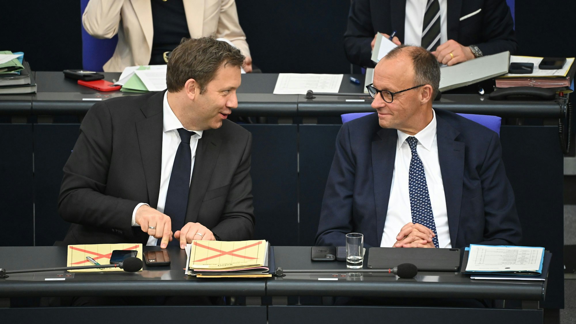 Bundeskanzler Friedrich Merz (CDU, r) und Lars Klingbeil (SPD), Bundesminister der Finanzen, unterhalten sich nach der Regierungserklärung im Plenum des Bundestags.