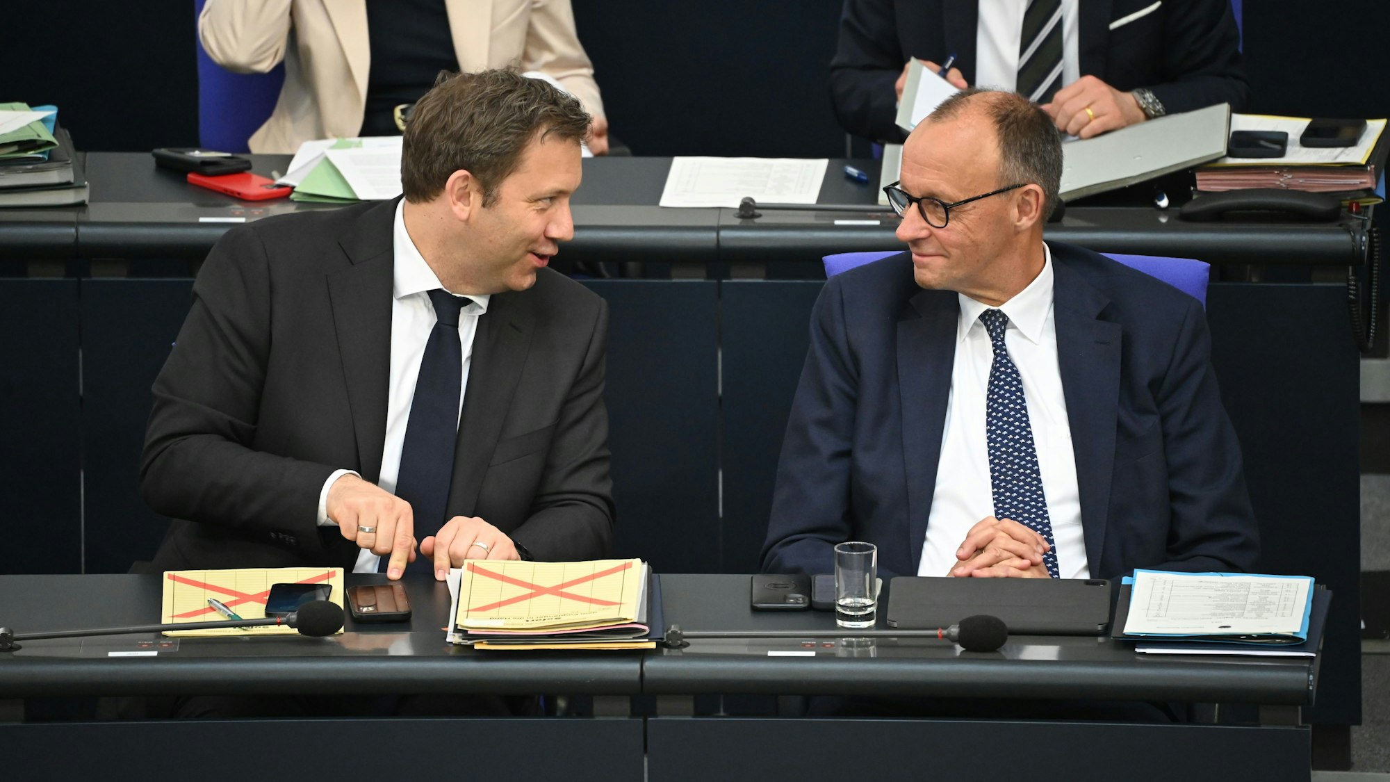 Bundeskanzler Friedrich Merz (CDU, r) und Lars Klingbeil (SPD), Bundesminister der Finanzen, unterhalten sich nach der Regierungserklärung im Plenum des Bundestags.