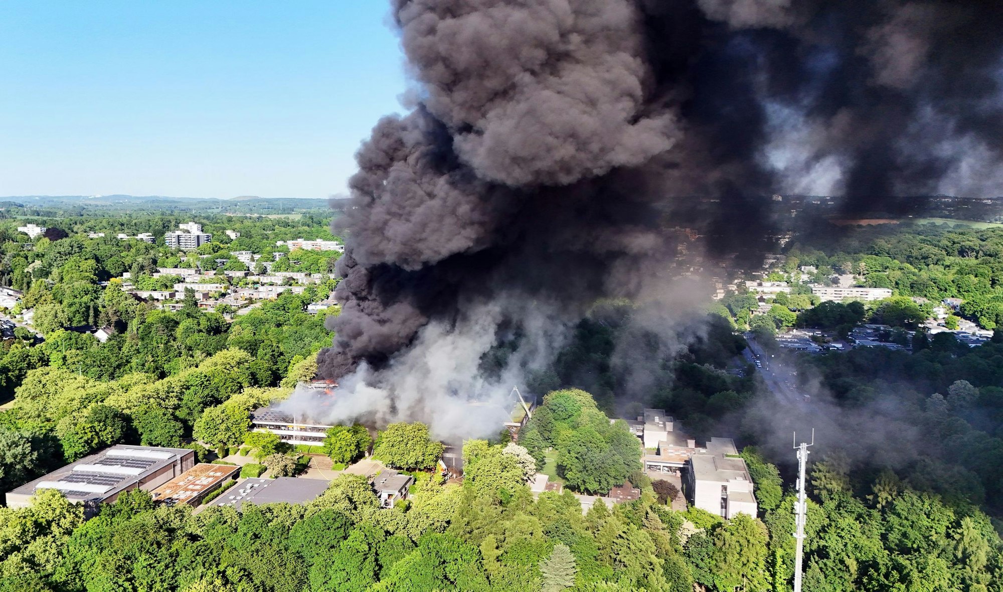 Nach dem Ausbruch eines großen Feuers in einem Schulzentrum in Erkrath bei Düsseldorf kämpfen Einsatzkräfte weiterhin gegen den Brand.