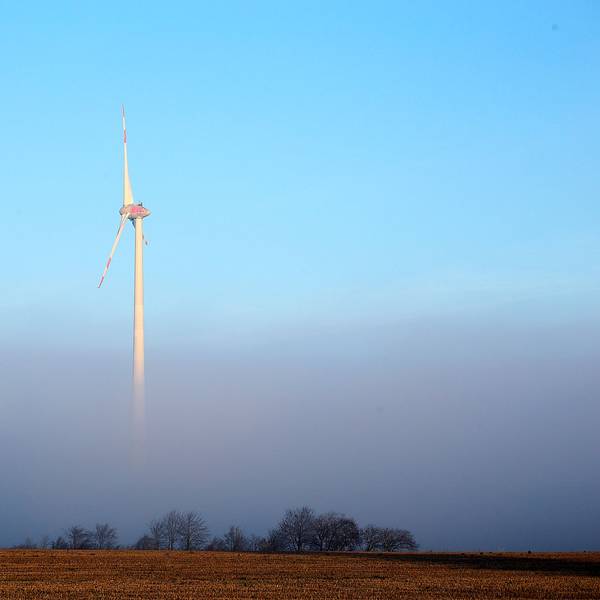 Ein Windrad steht im Nebel.