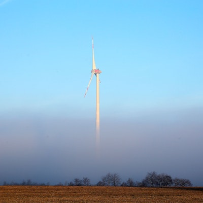 Ein Windrad steht im Nebel.