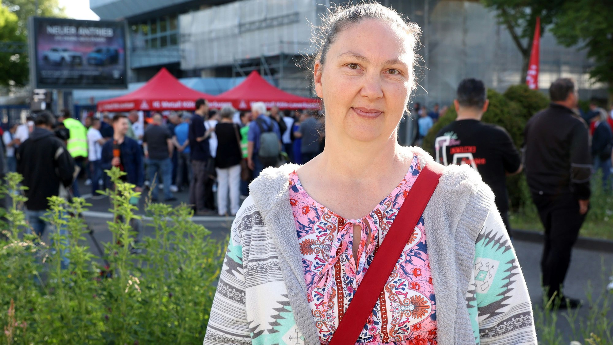Janet Pickhardt trägt eine bunte Bluse und einen Strickcardigan und lächelt in die Kamera.