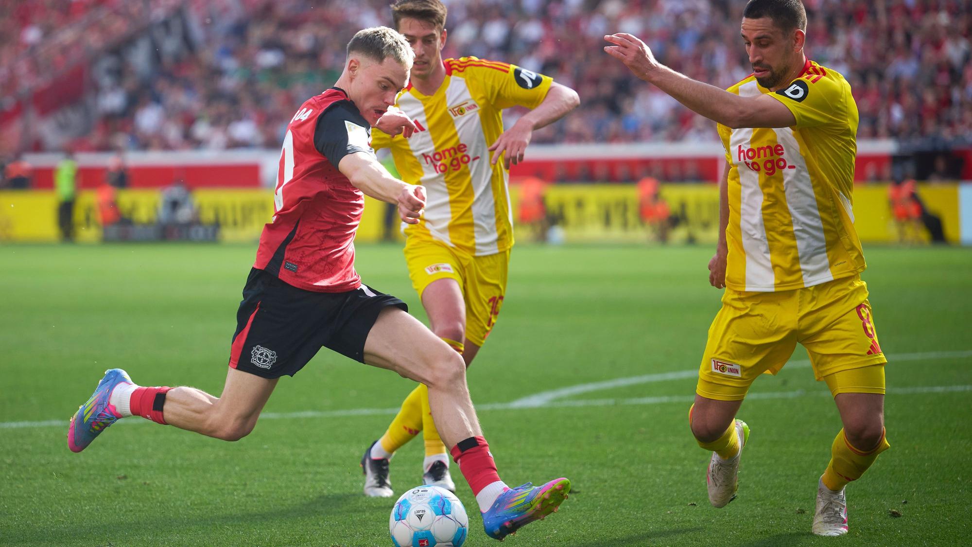 dpatopbilder - 12.04.2025, Nordrhein-Westfalen, Leverkusen: Fußball: Bundesliga, Bayer Leverkusen - 1. FC Union Berlin, 29. Spieltag, BayArena. Leverkusens Florian Wirtz (l) und Rani Khedira von Union in Aktion. Foto: Bernd Thissen/dpa - WICHTIGER HINWEIS: Gemäß den Vorgaben der DFL Deutsche Fußball Liga bzw. des DFB Deutscher Fußball-Bund ist es untersagt, in dem Stadion und/oder vom Spiel angefertigte Fotoaufnahmen in Form von Sequenzbildern und/oder videoähnlichen Fotostrecken zu verwerten bzw. verwerten zu lassen. +++ dpa-Bildfunk +++