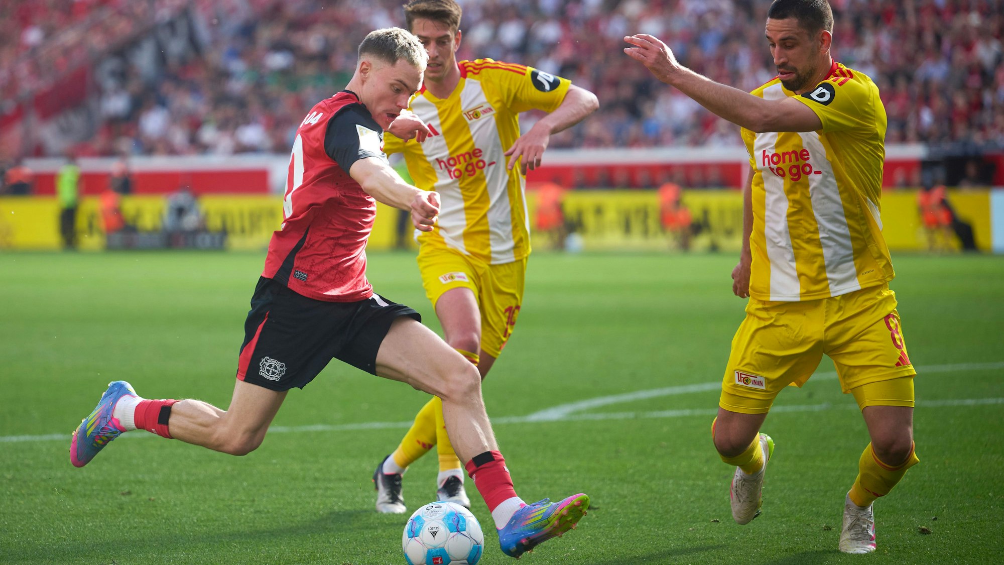 dpatopbilder - 12.04.2025, Nordrhein-Westfalen, Leverkusen: Fußball: Bundesliga, Bayer Leverkusen - 1. FC Union Berlin, 29. Spieltag, BayArena. Leverkusens Florian Wirtz (l) und Rani Khedira von Union in Aktion. Foto: Bernd Thissen/dpa - WICHTIGER HINWEIS: Gemäß den Vorgaben der DFL Deutsche Fußball Liga bzw. des DFB Deutscher Fußball-Bund ist es untersagt, in dem Stadion und/oder vom Spiel angefertigte Fotoaufnahmen in Form von Sequenzbildern und/oder videoähnlichen Fotostrecken zu verwerten bzw. verwerten zu lassen. +++ dpa-Bildfunk +++