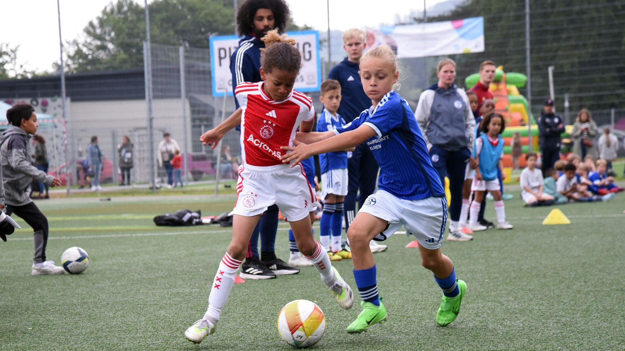 Fußballer von Ajax Amsterdam und dem FC Schalke 04 im Zweikampf.