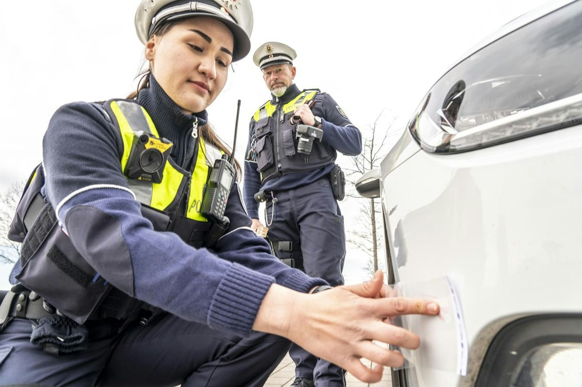 Polizeibeamte kontrollieren ein Fahrzeug. Die Polizei im Kreis Mettmann sucht Zeugen mehrerer Verkehrsunfallfluchten.