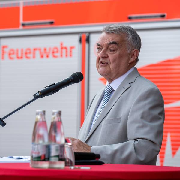 Ehrung für Fluthelfer in Köln, NRW-Innenminister Herbert Reul (CDU) spricht, im Hintergrund ist ein Feuerwehrauto zu sehen.