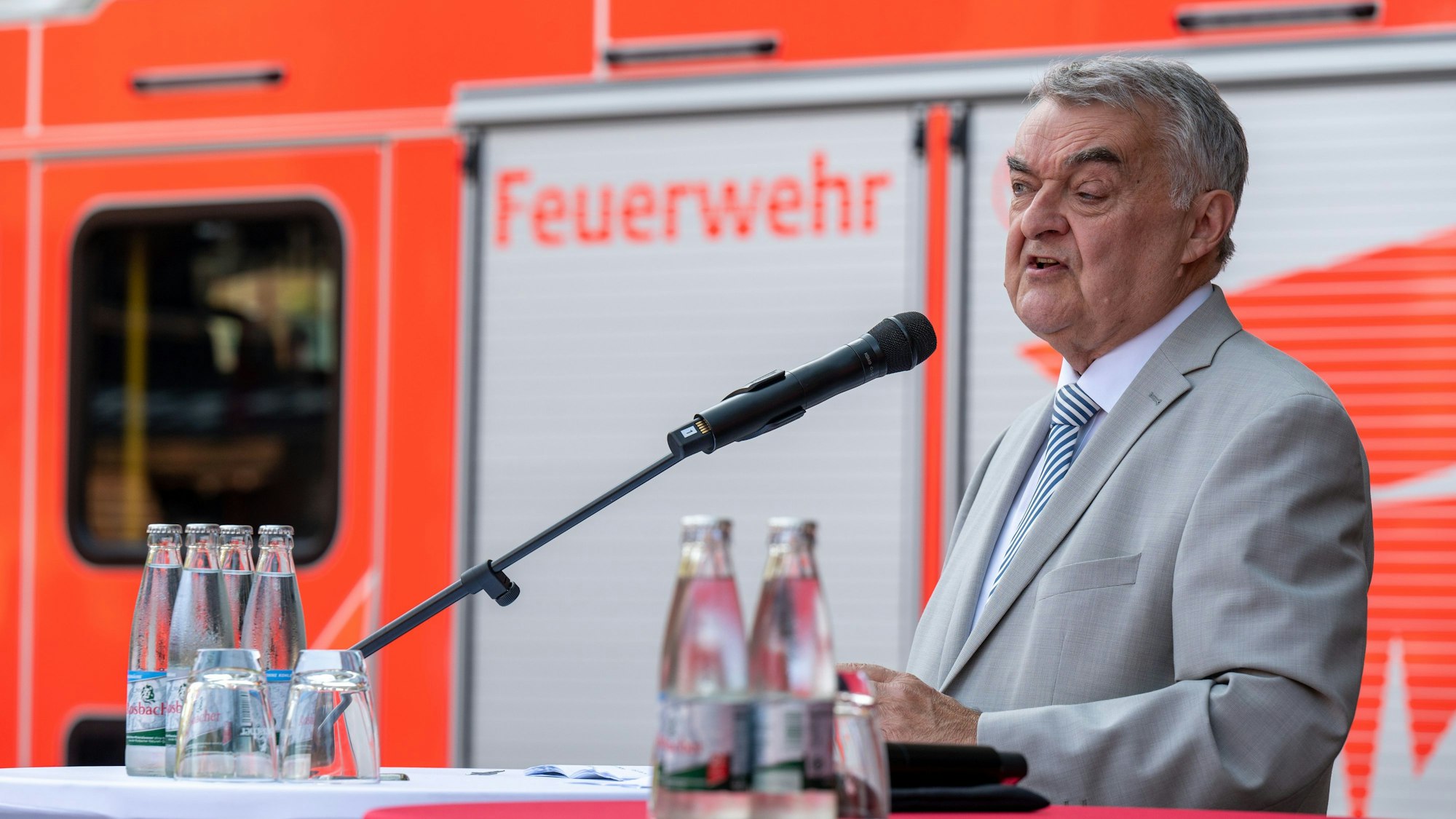 Ehrung für Fluthelfer in Köln, NRW-Innenminister Herbert Reul (CDU) spricht, im Hintergrund ist ein Feuerwehrauto zu sehen.
