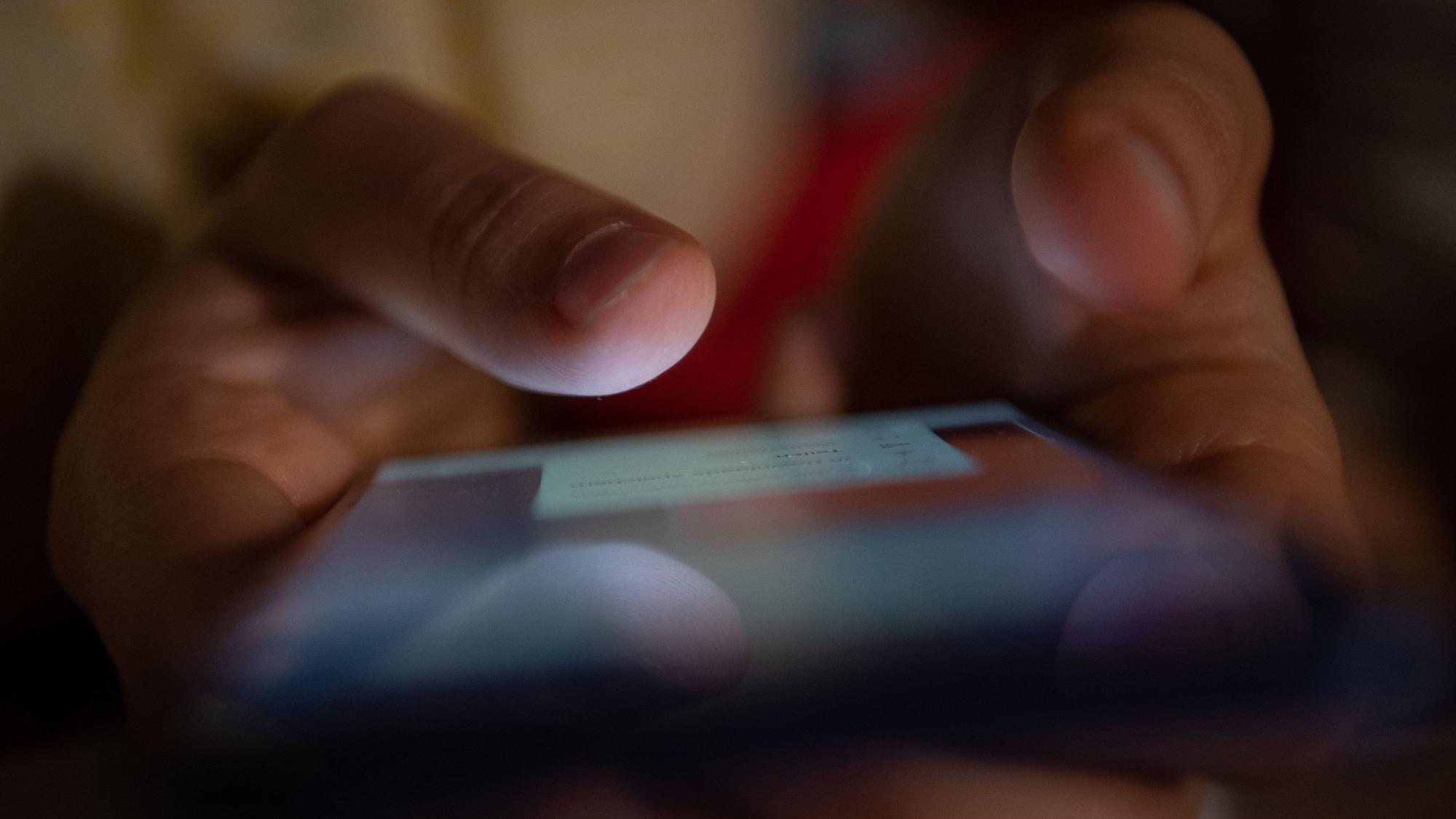 Ein Smartphone wird gehalten.