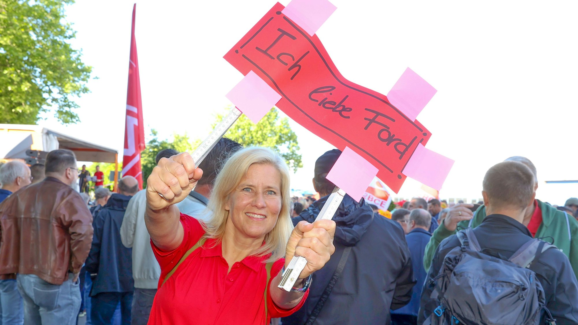 Ivonne Lucka hält ein rotes Papp-Schild mit der Aufschrift "Ich liebe Ford".
