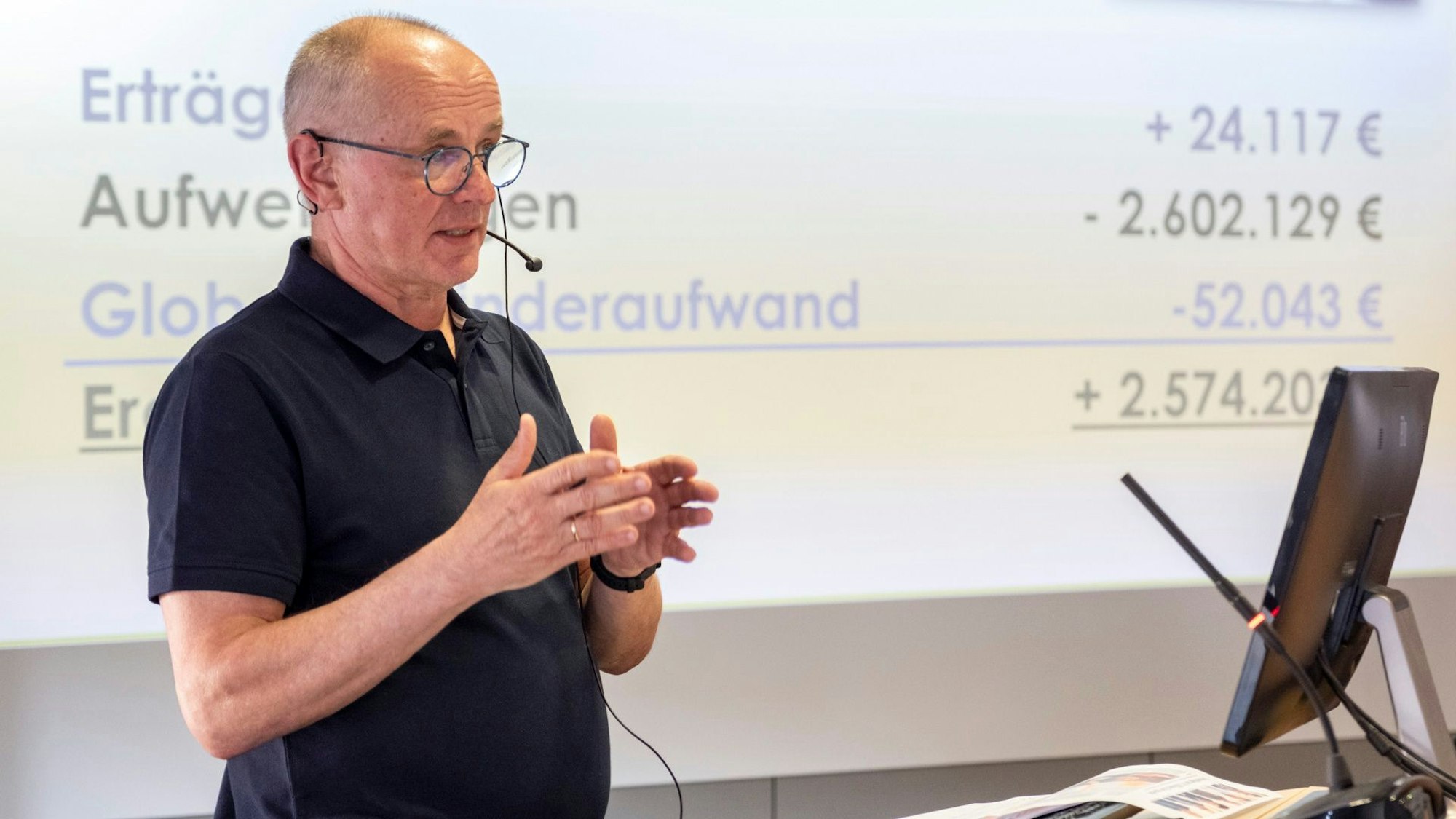 Ralf Claßen mit Headset und schwarzem Kurzarmhemd bei der Ratssitzung in Mechernich.