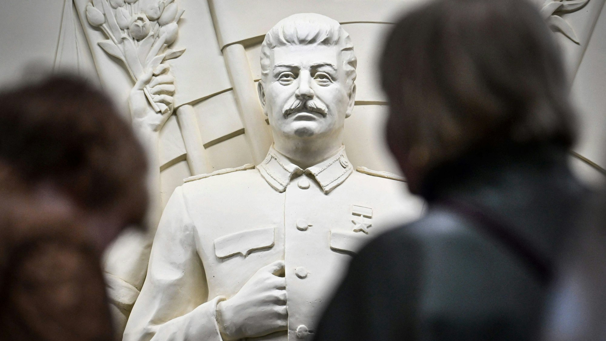 Pendler vor dem neu enthüllten Hochrelief von Joseph Stalin in der Taganskaja-Metrostation in Moskau.