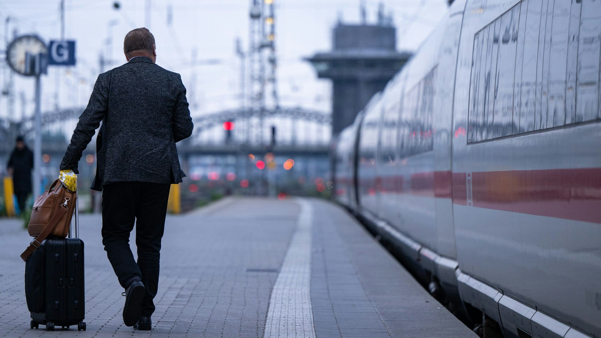 Ein Reisender geht über einen Bahnsteig der Deutschen Bahn.
