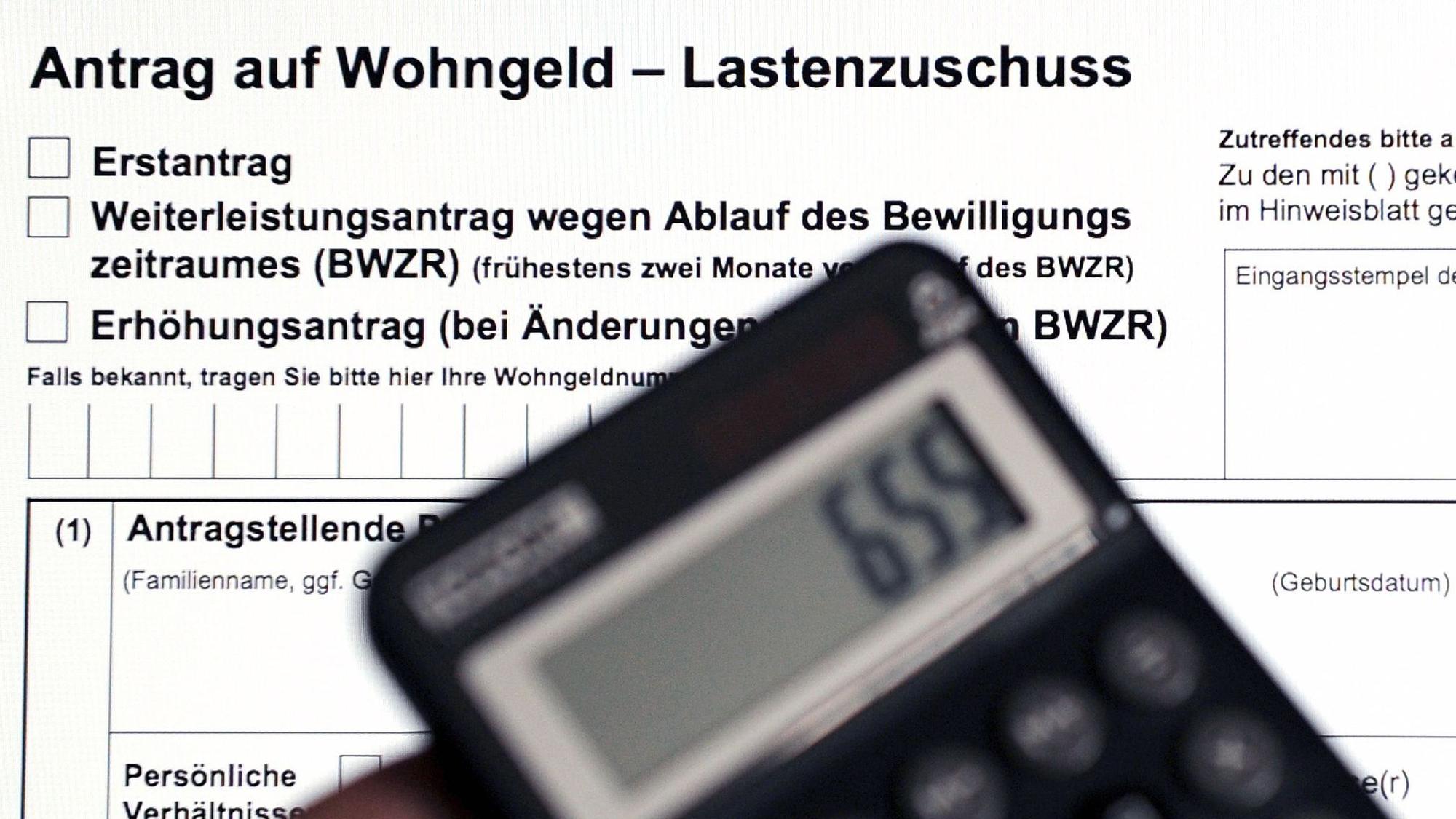 Ein Wohngeldantrag auf dem Bildschirm eines Laptops und ein Taschenrechner.