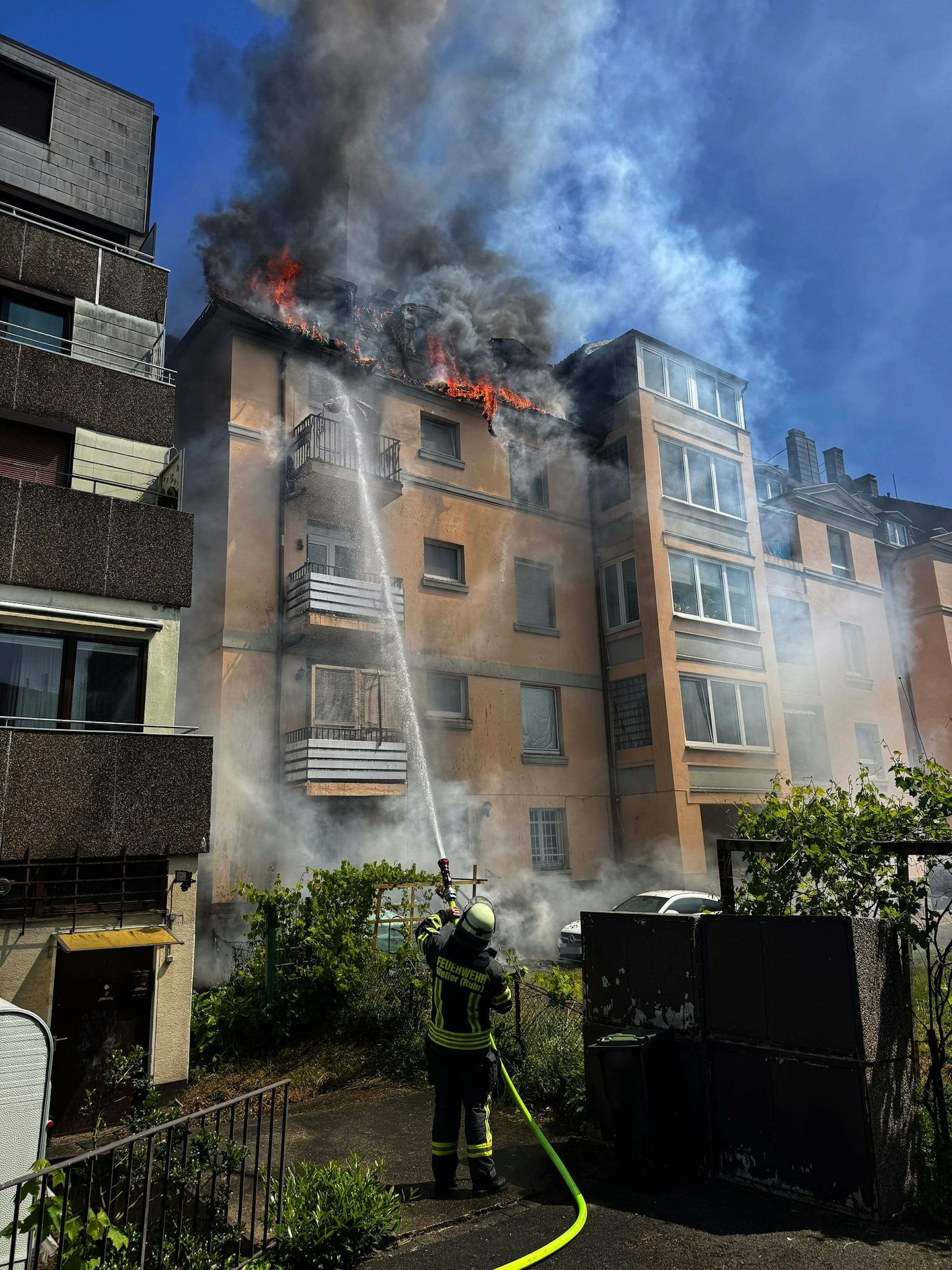 Feuerwehrleute retten eine Mutter mit ihrer Tochter aus dem brennenden Dachgeschoss.