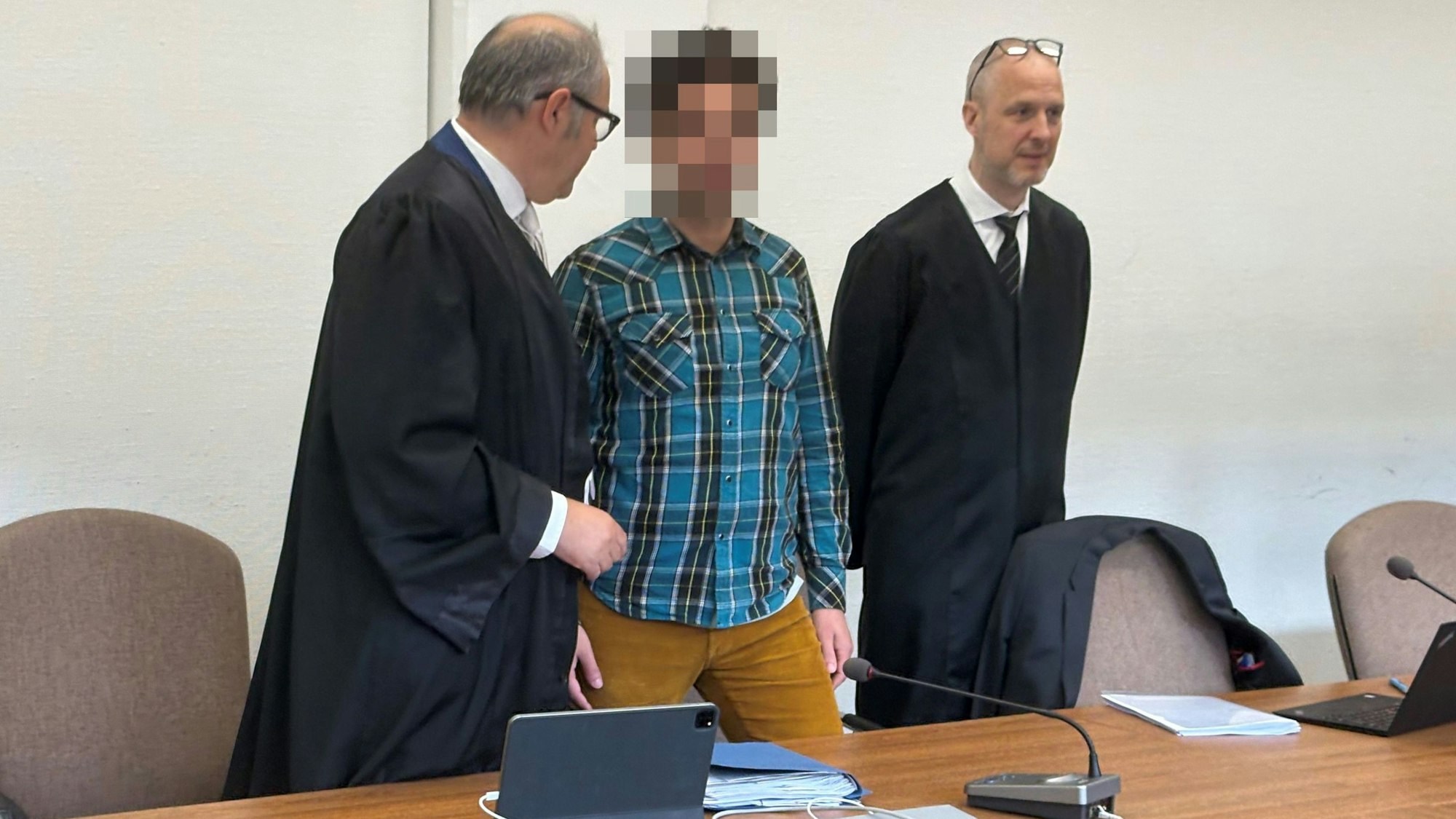 Der Angeklagte mit seinen Verteidigern beim Prozessauftakt im Kölner Landgericht