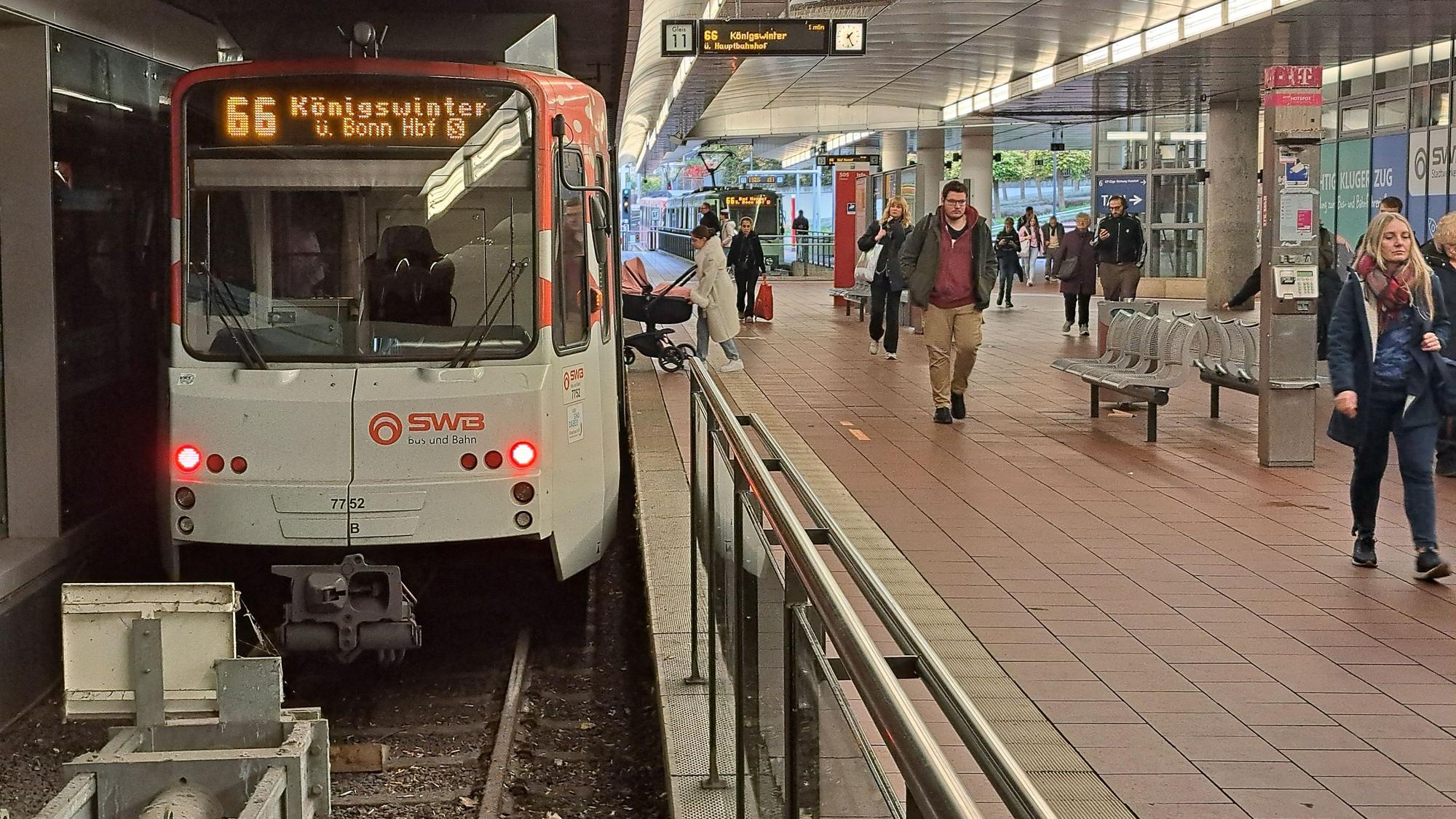 Die Stadtbahnlinie 66 hält am Siegburger Bahnhof. Am Gleis laufen Menschen oder steigen ein und aus.