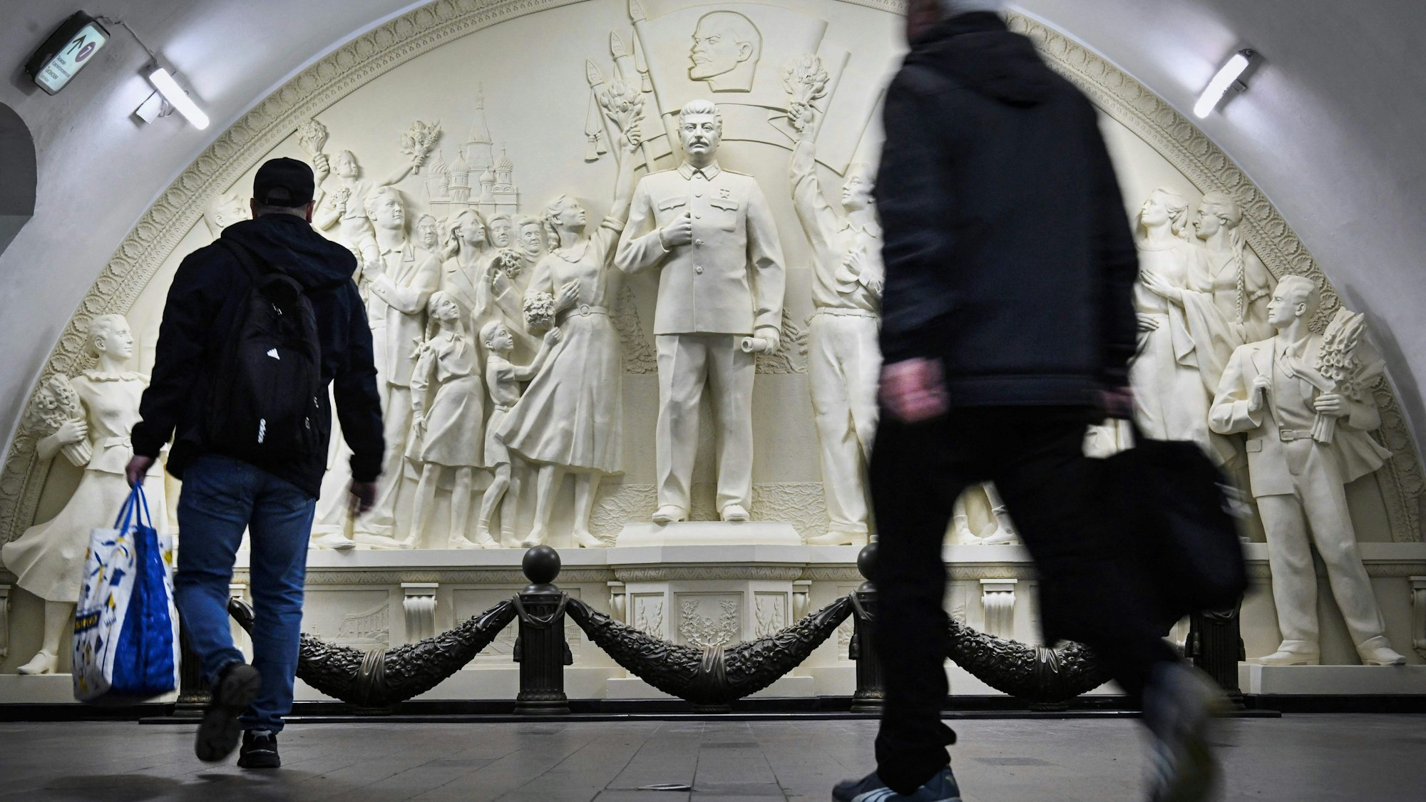 Pendler vor dem neu enthüllten Hochrelief von Joseph Stalin in der Taganskaja-Metrostation in Moskau.