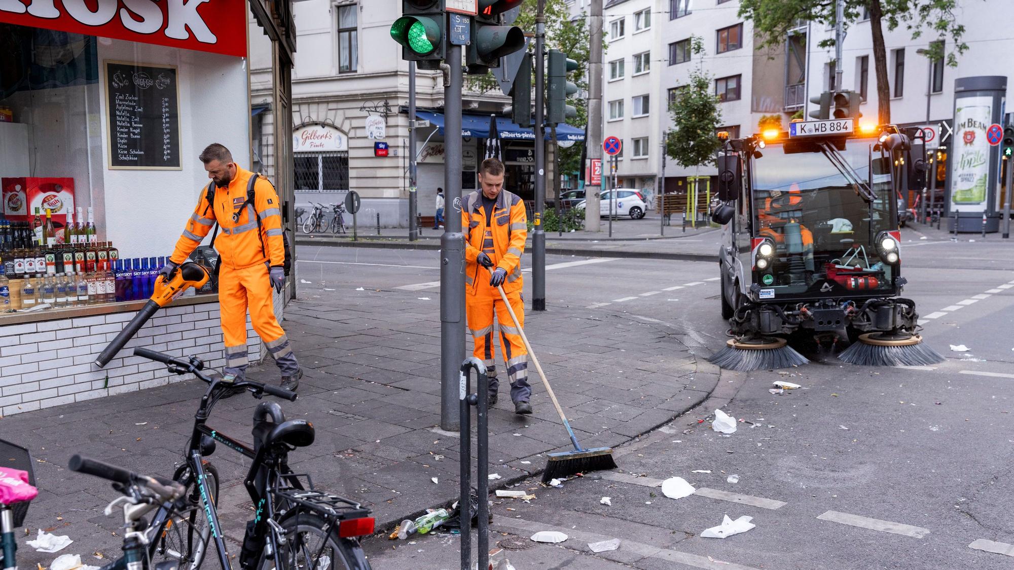 Ein AWB-Trupp beseitigt den Müll auf der Zülpicher Straße nach einer durchfeierten Nacht im Mai (Archiv)