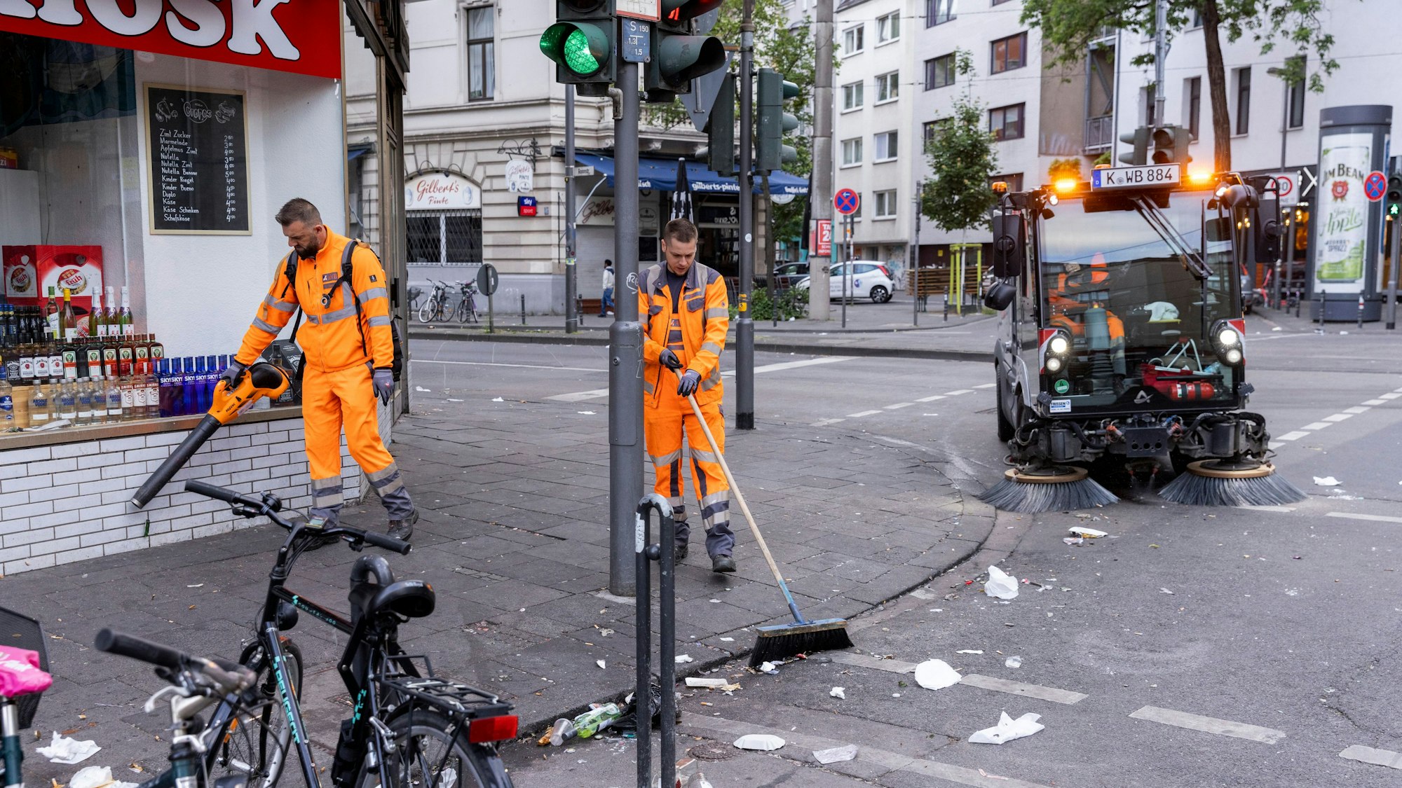 Ein AWB-Trupp beseitigt den Müll auf der Zülpicher Straße nach einer durchfeierten Nacht im Mai (Archiv)