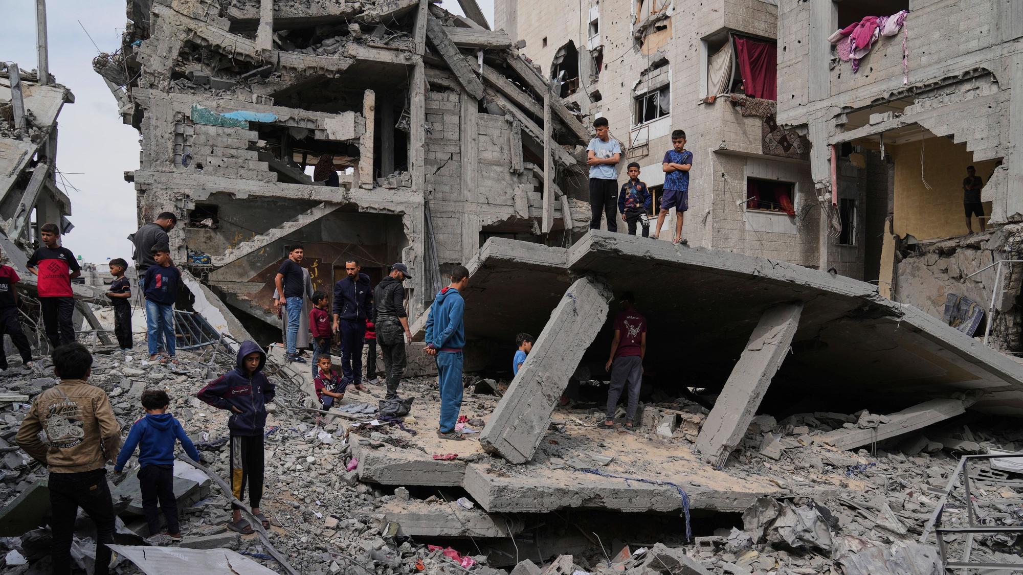 Palästinenser blicken auf die Trümmer des durch israelische Luftangriffe zerstörten Hauses der Familie Al-Lahham in Chan Junis, Gazastreifen.