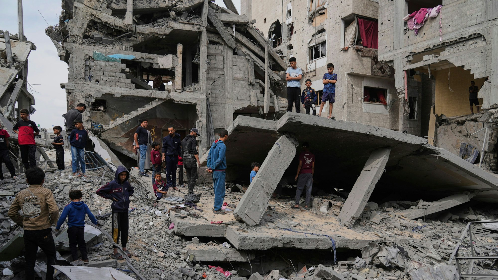 Palästinenser blicken auf die Trümmer des durch israelische Luftangriffe zerstörten Hauses der Familie Al-Lahham in Chan Junis, Gazastreifen.