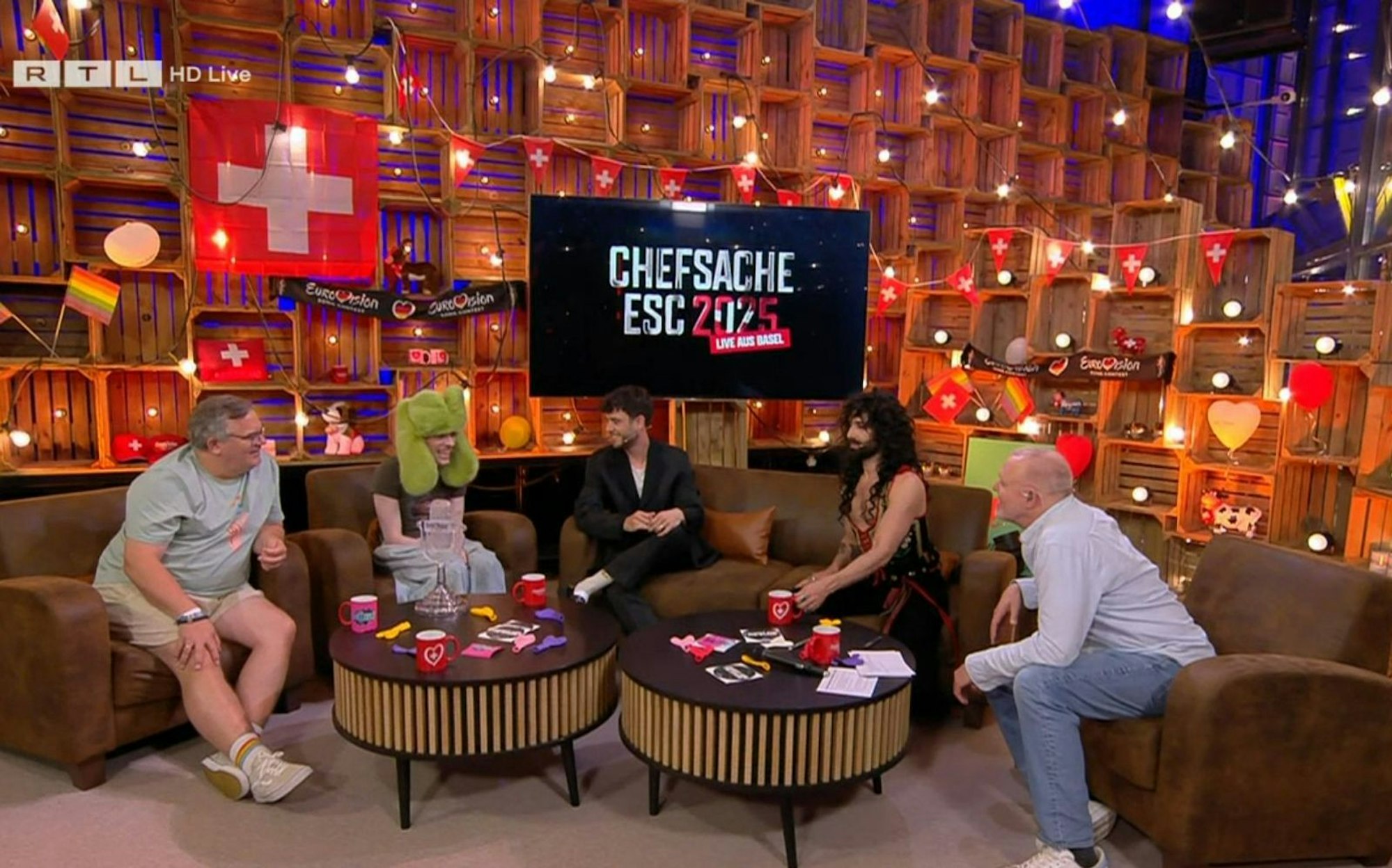 Als Nemo (Zweiter von links) anmerkt, dass es sich ja um den 69. ESC handelt, macht Stefan Raab (rechts) eine schlüpfrige Bemerkung in Richtung von Elton (links). Mit dessen Reaktion hat der RTL-Moderator aber offenbar nicht gerechnet. (Bild: RTL)