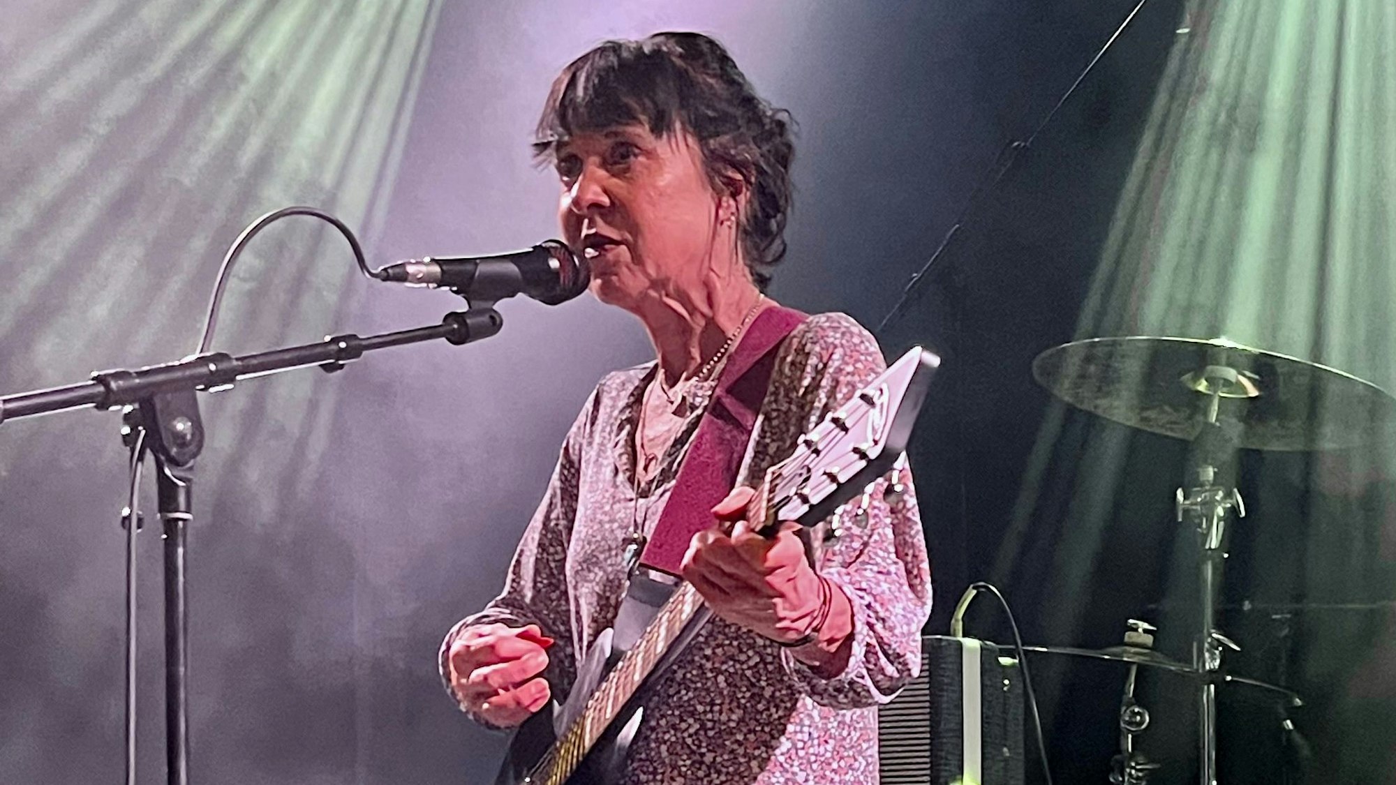 Kristin Hersh trägt ein Kleid mit Blümchenmuster und spielt E-Gitarre