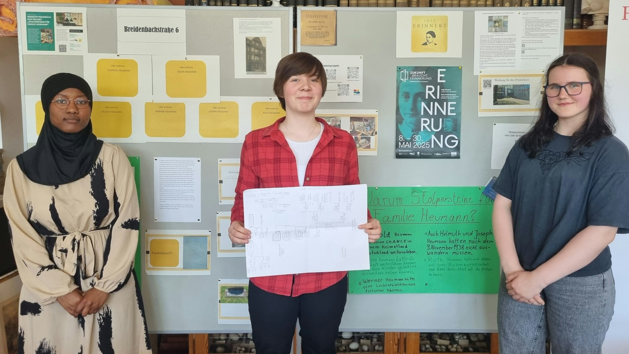 Drei Schülerinnen stehen vor einer Stellwand.