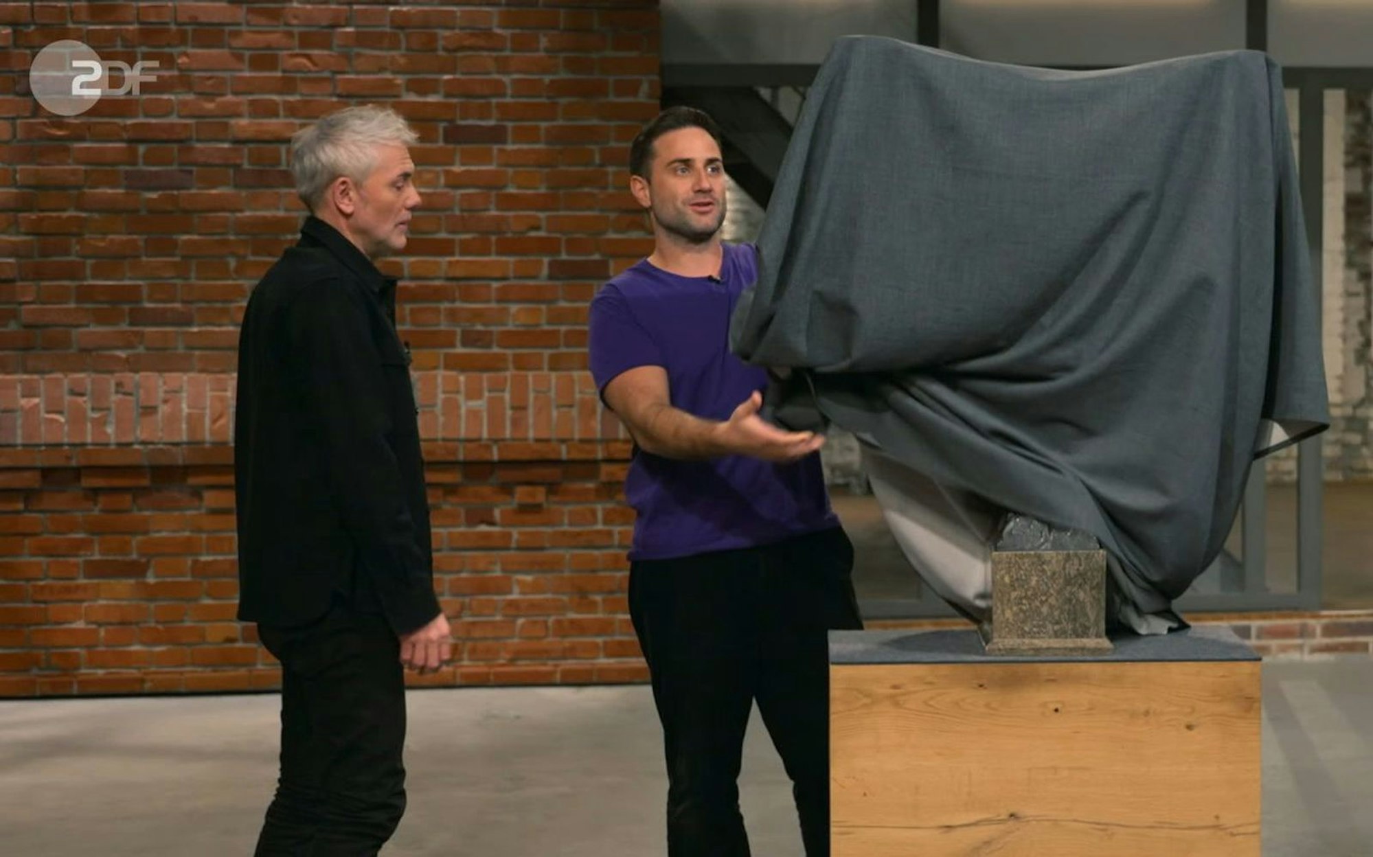 Was sich unter dem Tuch versteckte? Einer der „Bares für Rares“-Händler hatte bereits eine Vorahnung. Und er und seine Kollegen wollten das „imposante Stück“ dann auch (fast) alle haben ... (Bild: ZDF)