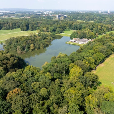 Blick auf den als „Kampfbahn“ bezeichneten Rasenplatz in der Nähe des Fort Deckstein am Decksteiner Weiher mit dem Haus am See.