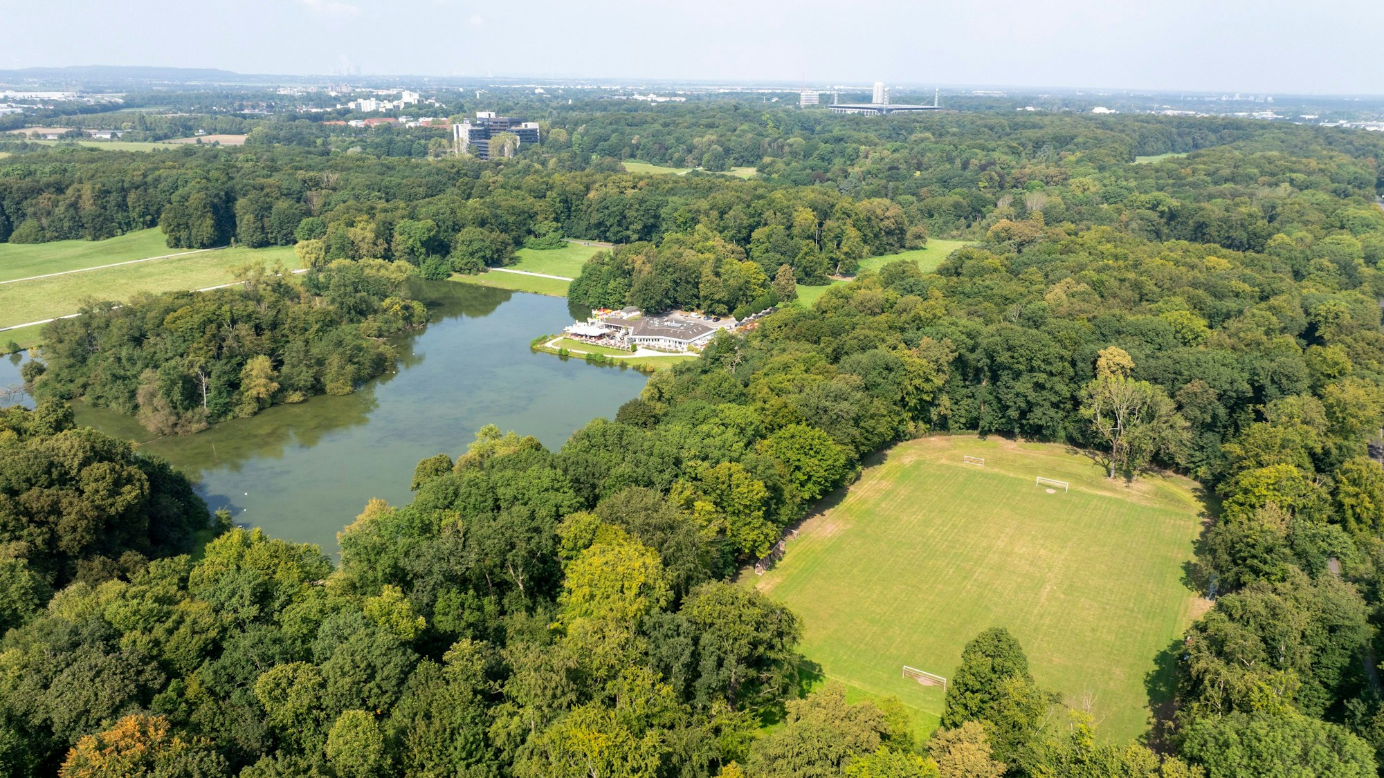 Blick auf den als „Kampfbahn“ bezeichneten Rasenplatz in der Nähe des Fort Deckstein am Decksteiner Weiher mit dem Haus am See.