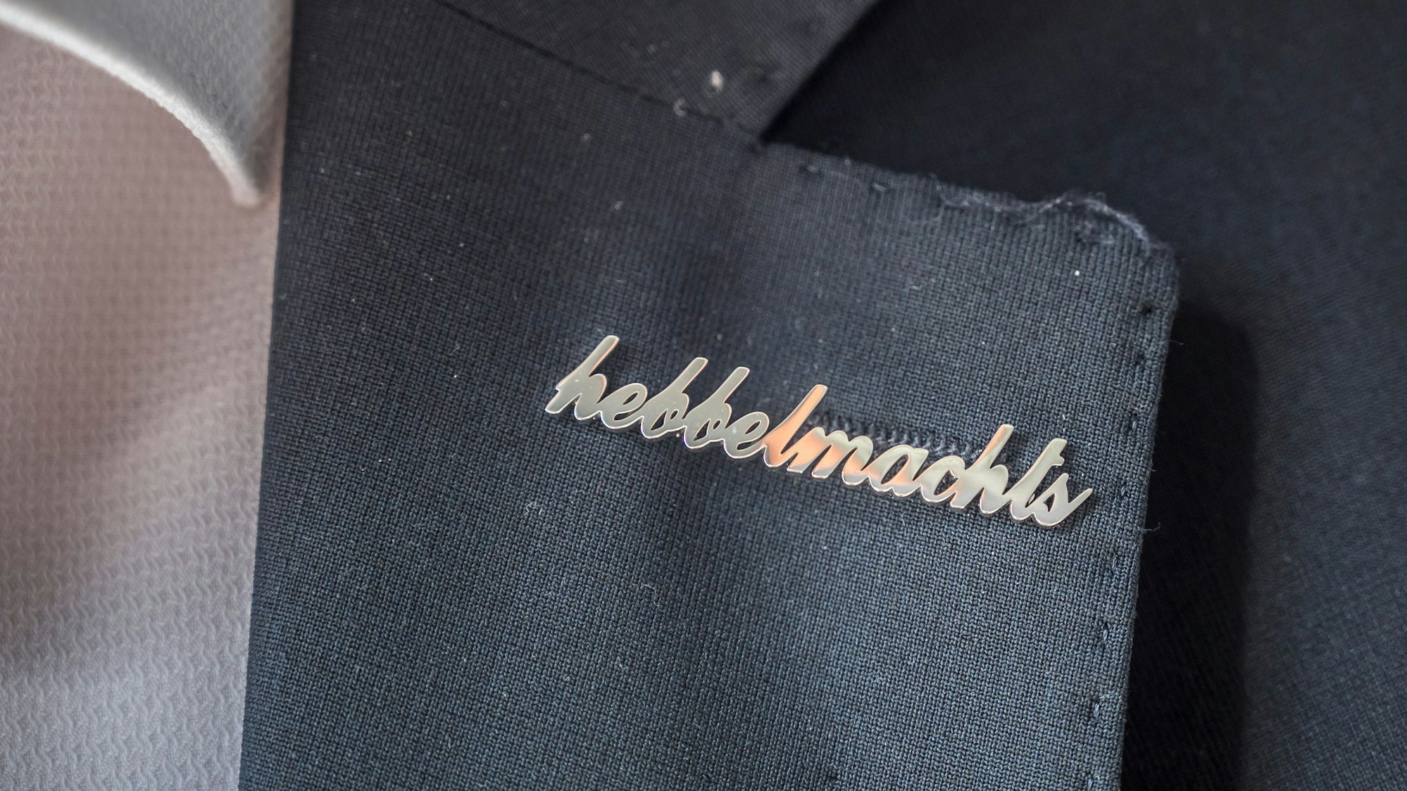 Anstecker mit „Hebbel machts“ am Revers des Kandidaten