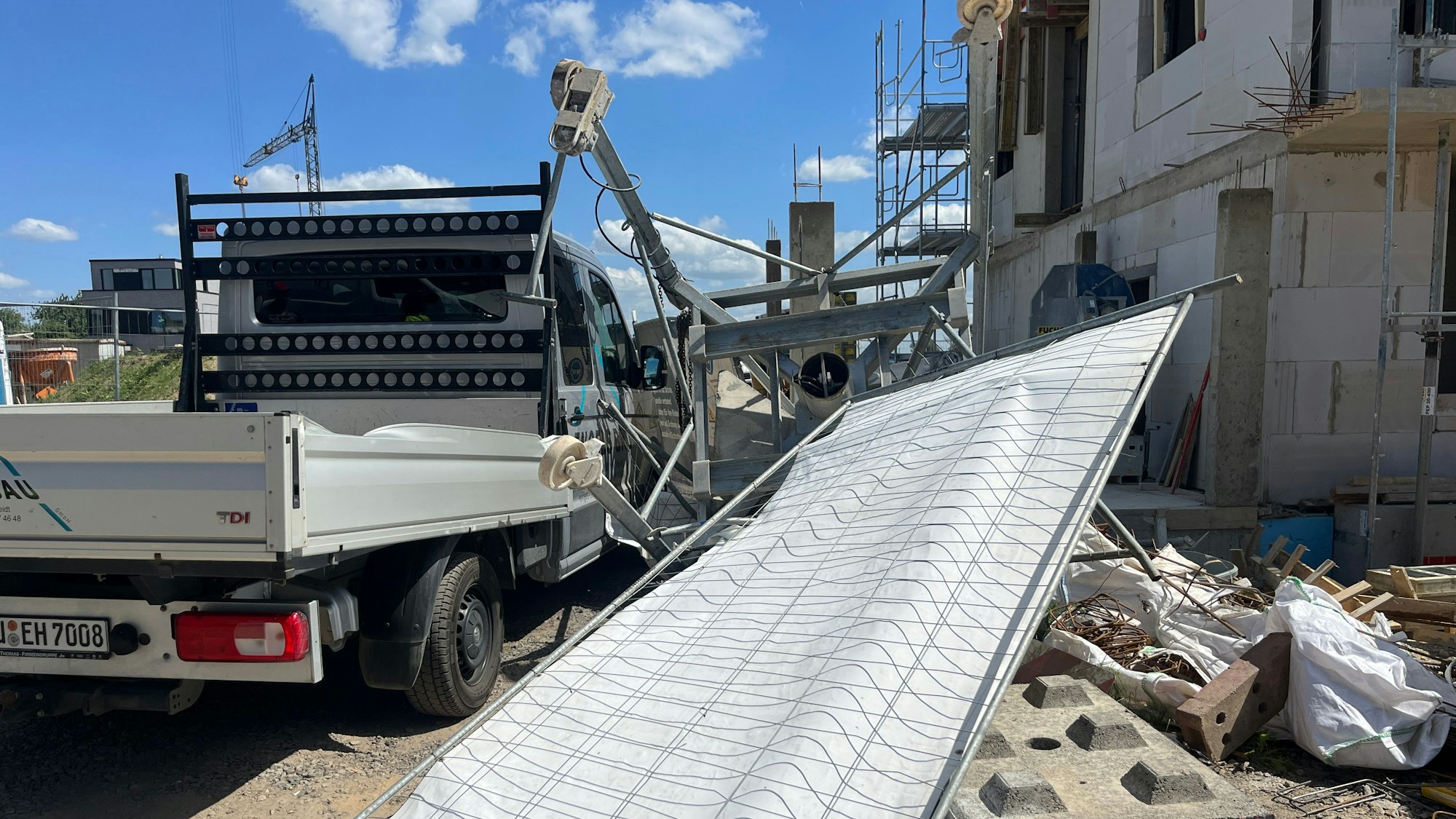 Eine Baumaschine, die am Haken gehangen hatte, stürzte zu Boden und gegen einen Lastwagen.