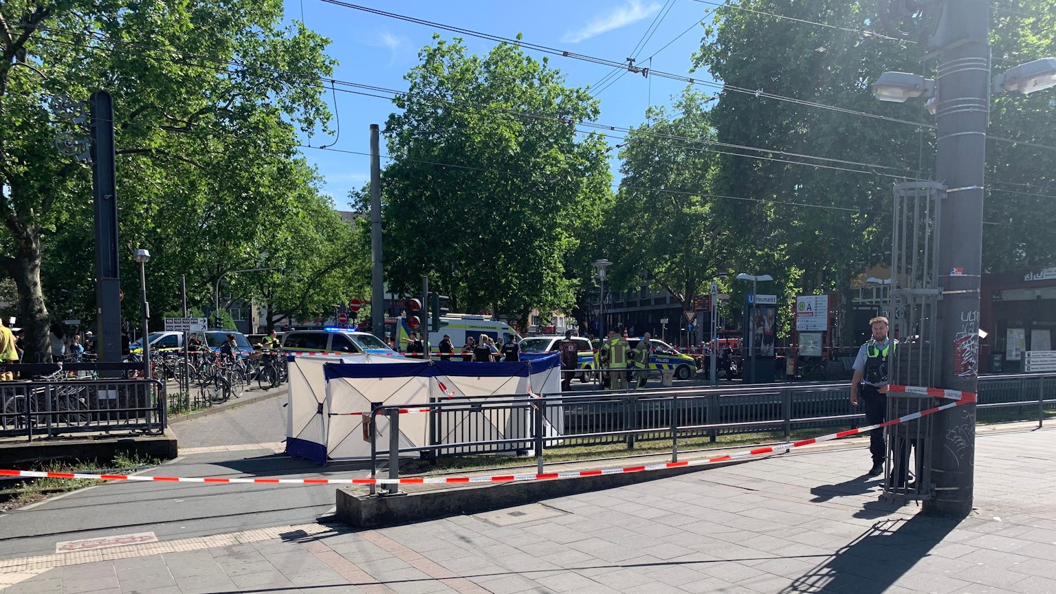 Einsatzkräfte sperren den Unfallort an der KVB-Haltestelle Heumarkt, nachdem ein Fußgänger von einer Bahn erfasst und getötet worden ist.