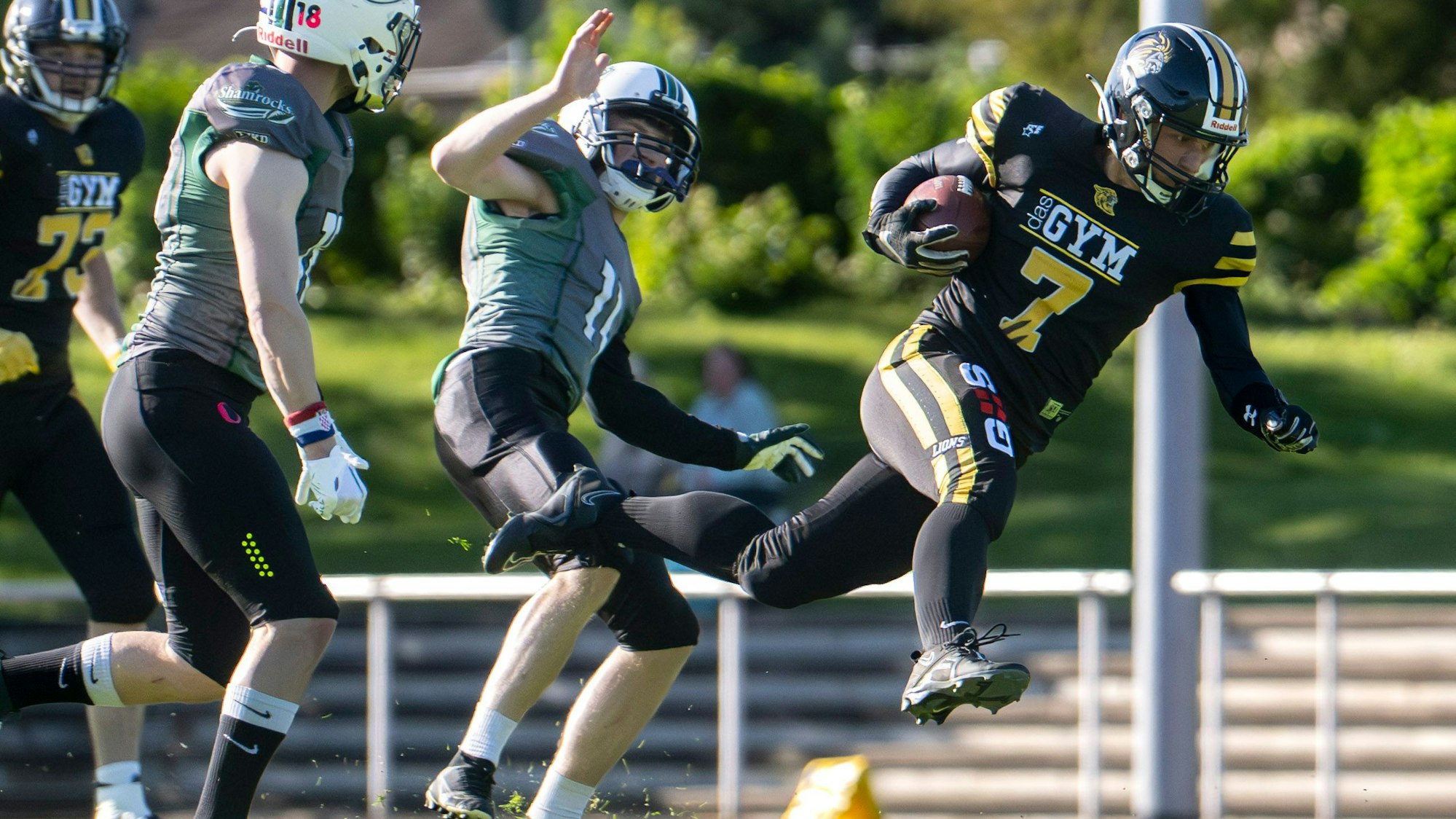 Das Bild zeigt, wie Jonas Schmitz von zwei Gegnern zu Fall gebracht wird.