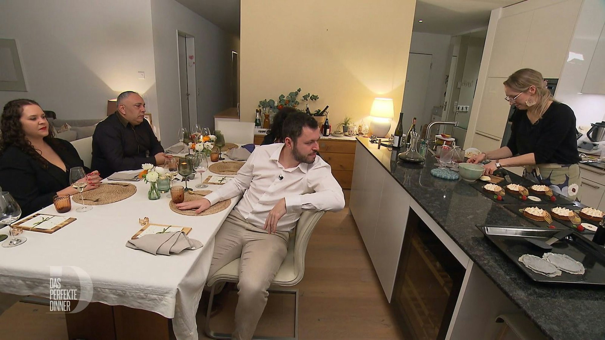 Die Gäste schauen Anja fasziniert beim detailverliebten Dekorieren des Desserts zu.
(Bild: RTL)